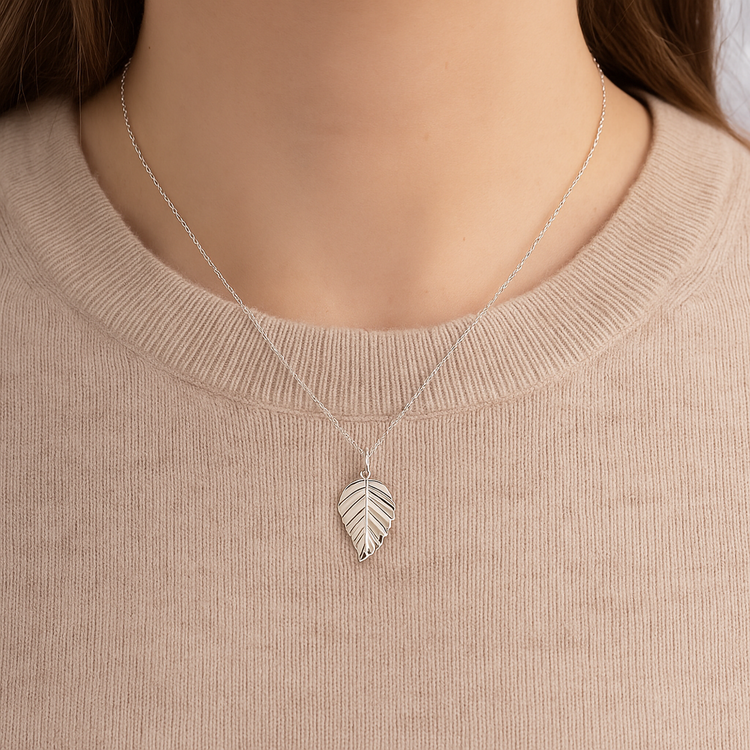 woman wearing silver leaf pendant