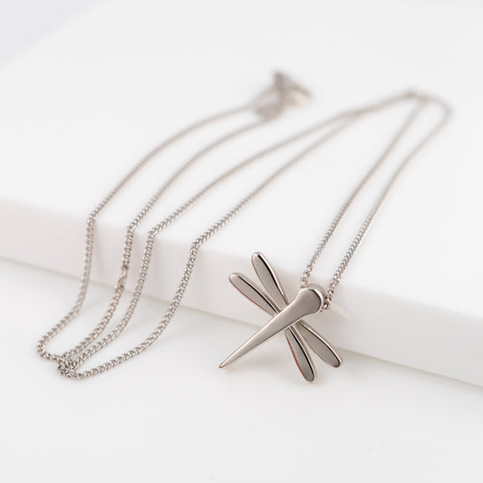 Silver dragonfly necklace with curb chain on a white background