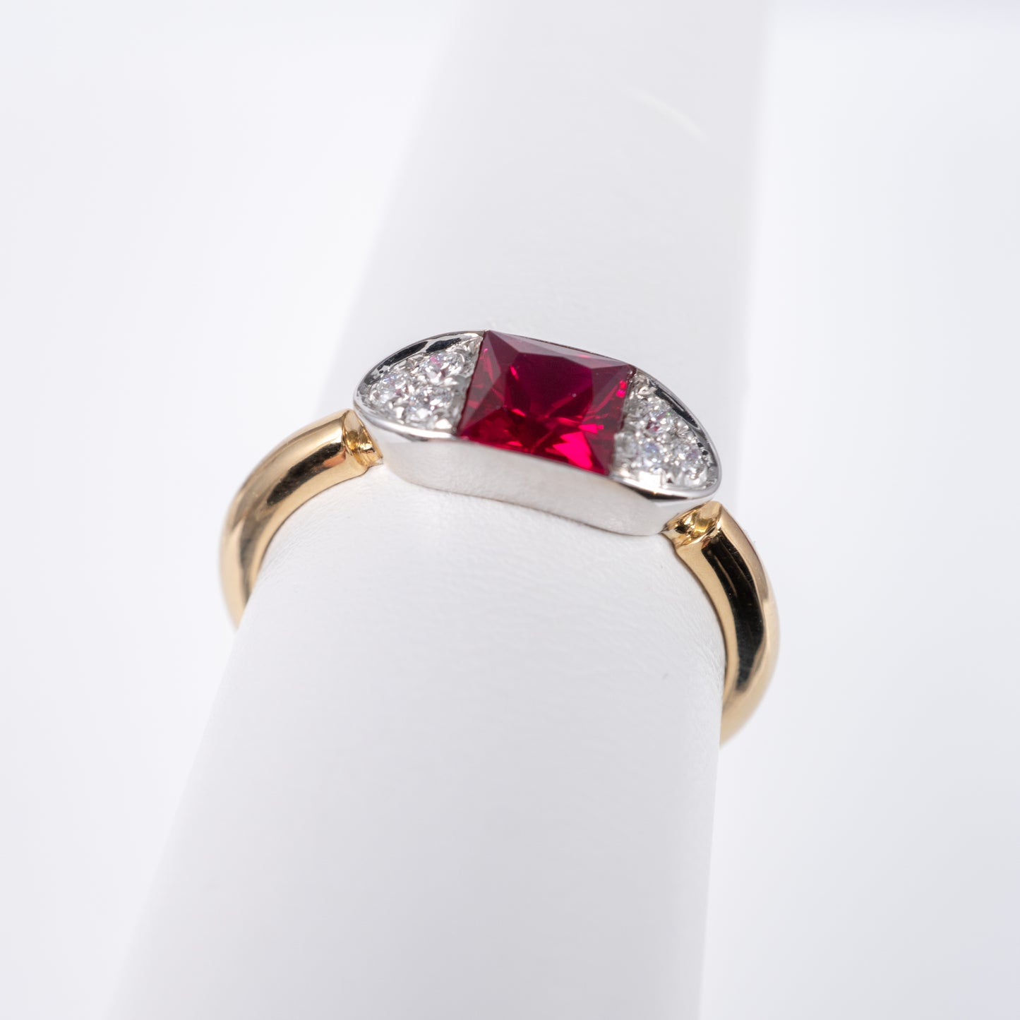 Contemporary ruby ring in 9ct gold, front view showcasing radiant-cut lab ruby with diamond accents and boat design by Hunters Fine Jewellery.