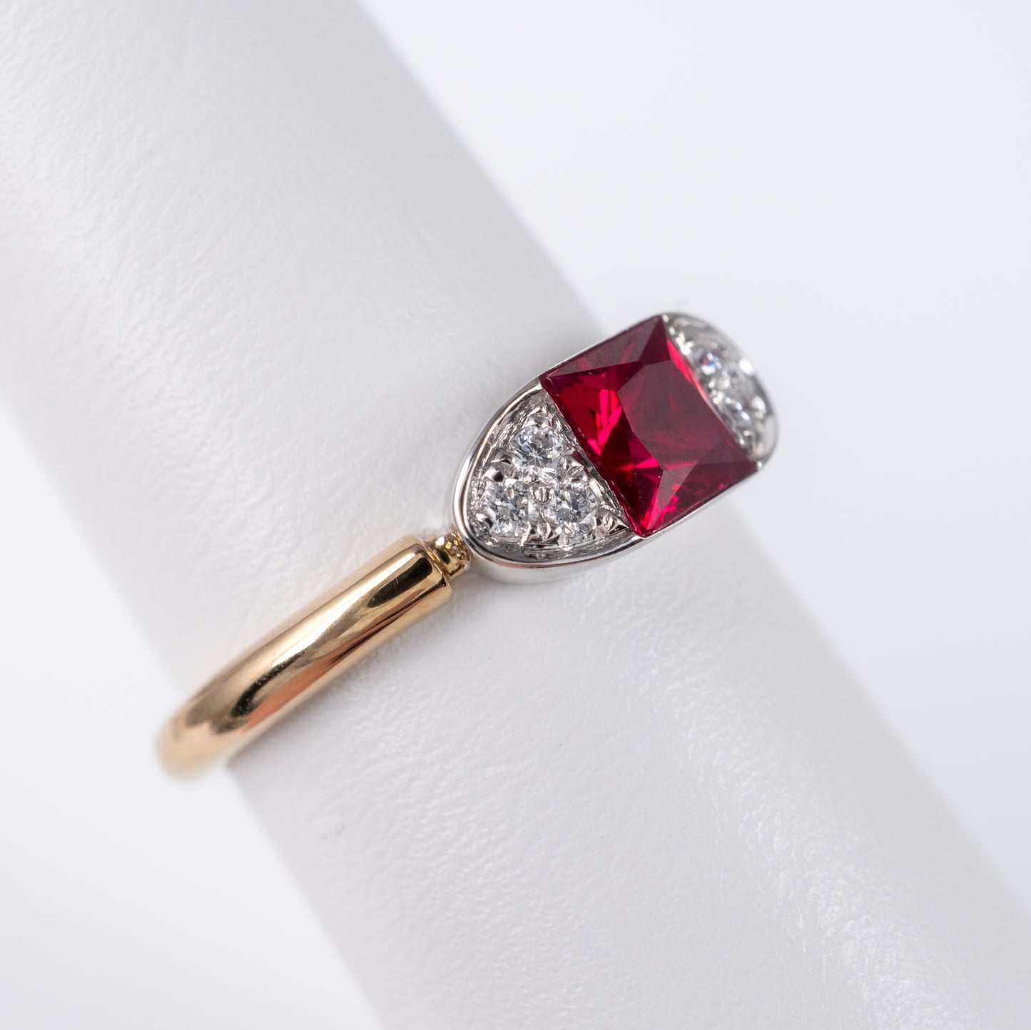 Contemporary ruby ring side close up with radiant-cut lab ruby and diamond accents, displayed by Hunters Fine Jewellery.