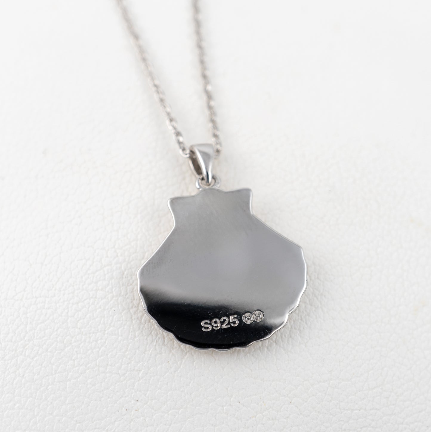 Detailed shot of hallmark 's925 MH' on scallop shell pendant