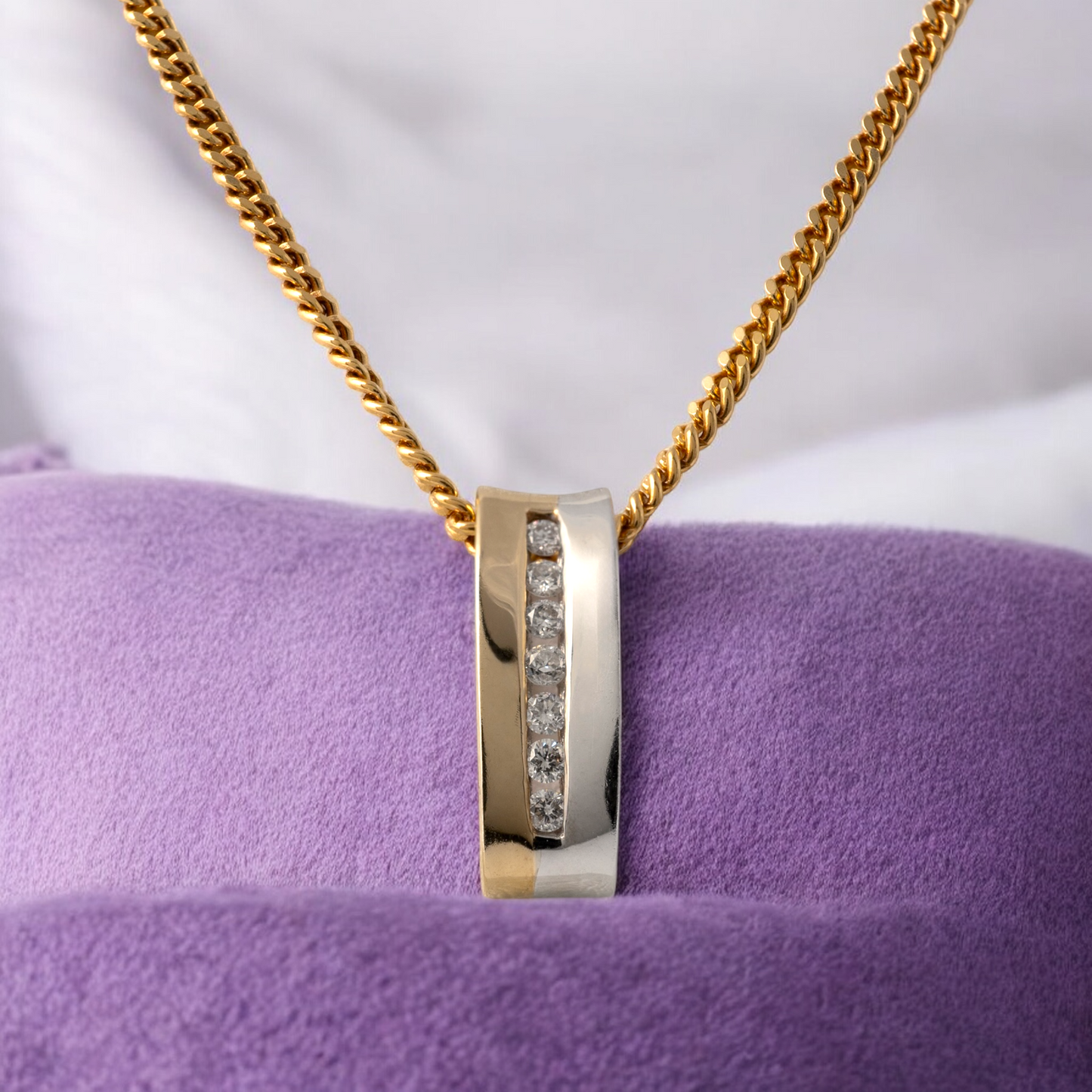 Two-tone 9ct gold diamond bar necklace displayed on a purple velvet cushion, showcasing its modern design and tension-set diamonds.