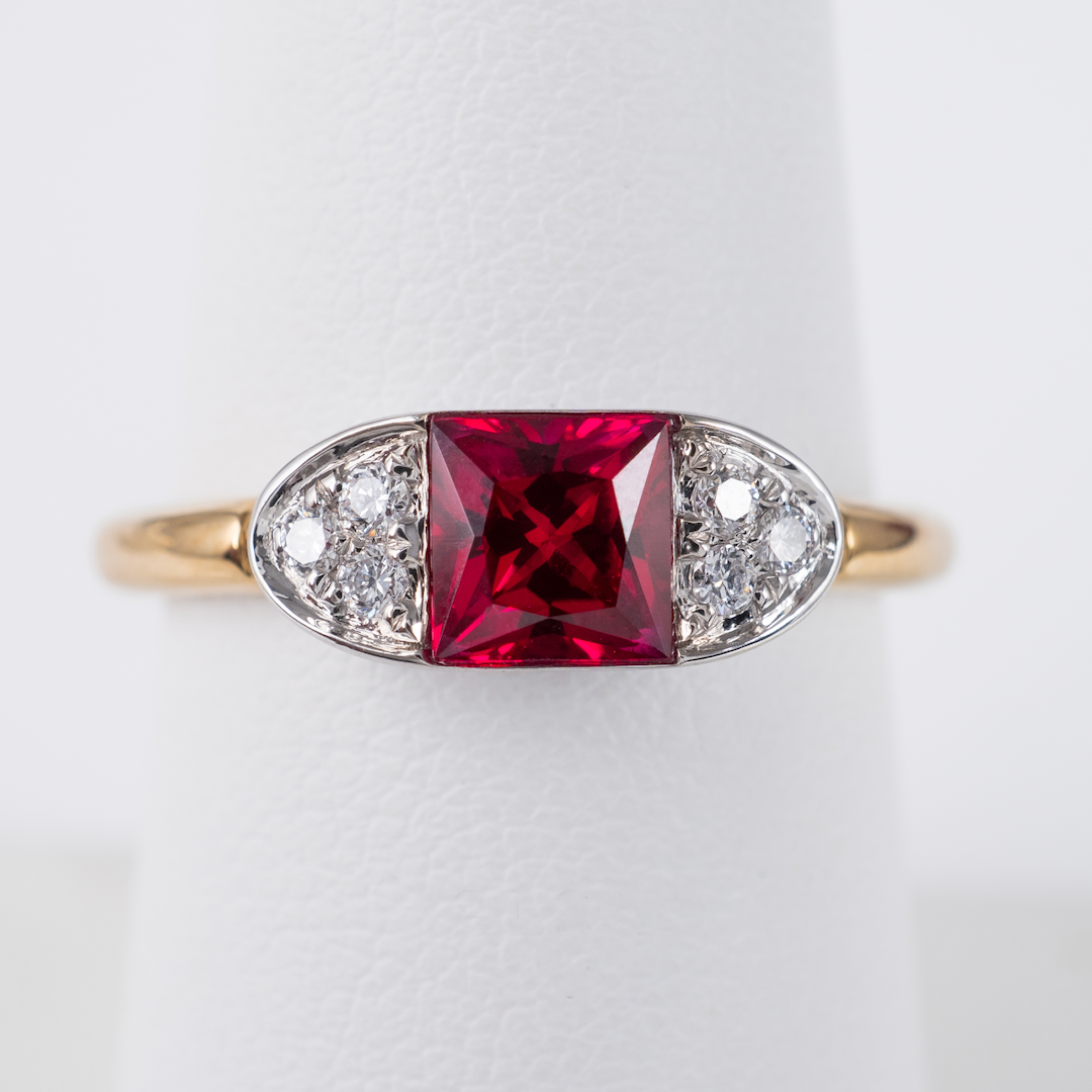 Front view of contemporary ruby ring in 9ct gold with radiant-cut lab ruby and diamond accents, displayed by Hunters Fine Jewellery.