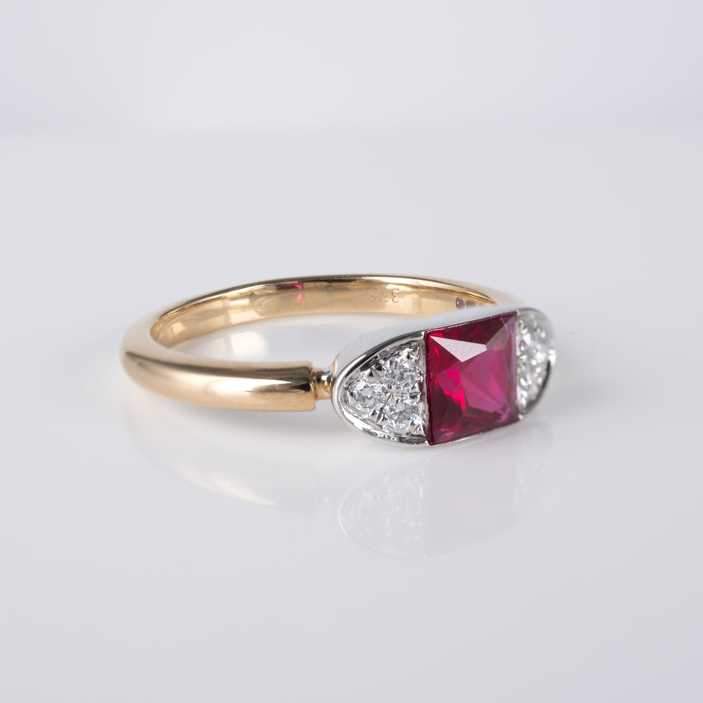 Side view of contemporary ruby ring in 9ct gold with radiant-cut lab ruby and diamond accents by Hunters Fine Jewellery.