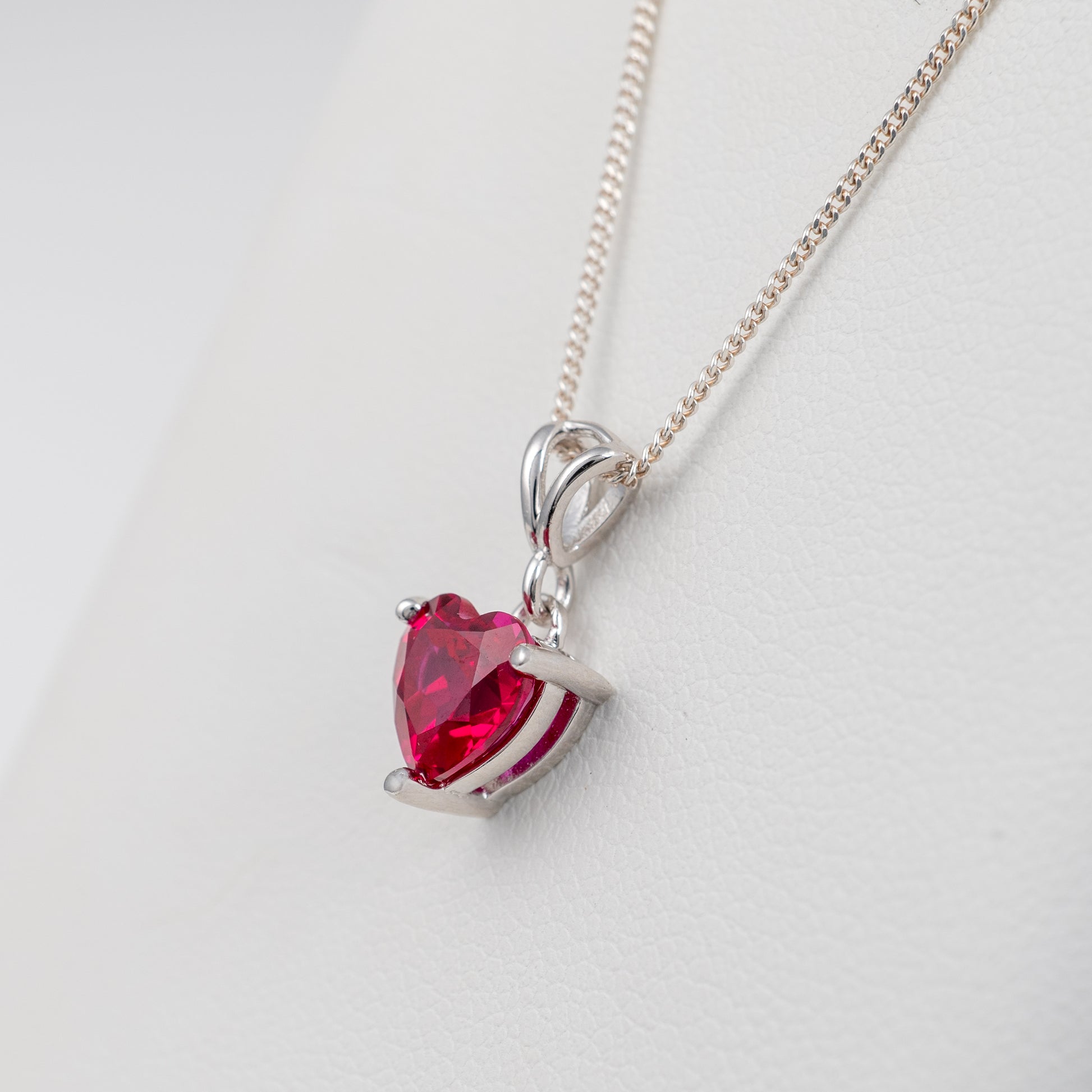 Side view of lab-grown ruby heart necklace with split bail