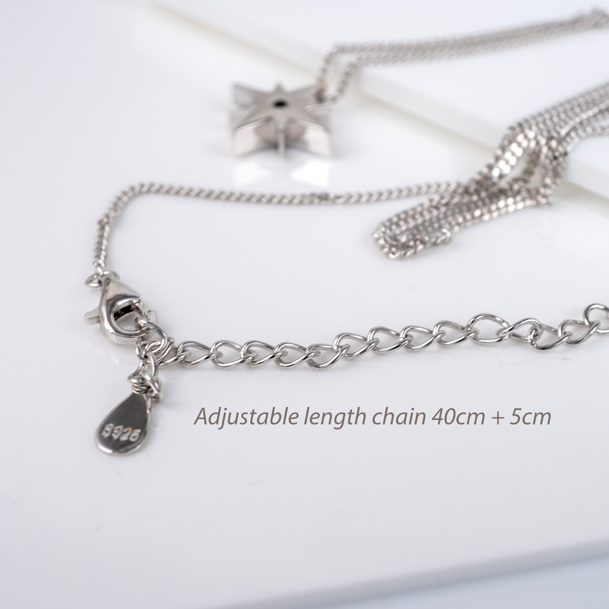 adjustable 925 silver curb chain with celestial pendant laid flat