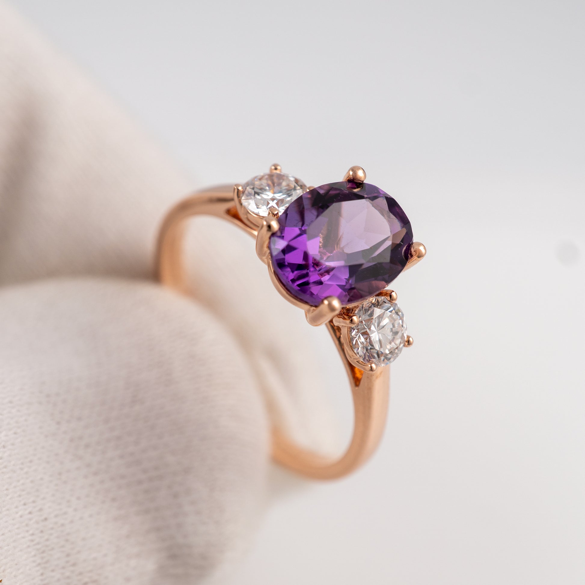 February birthstone amethyst three stone ring in 9ct rose gold – shown on hand