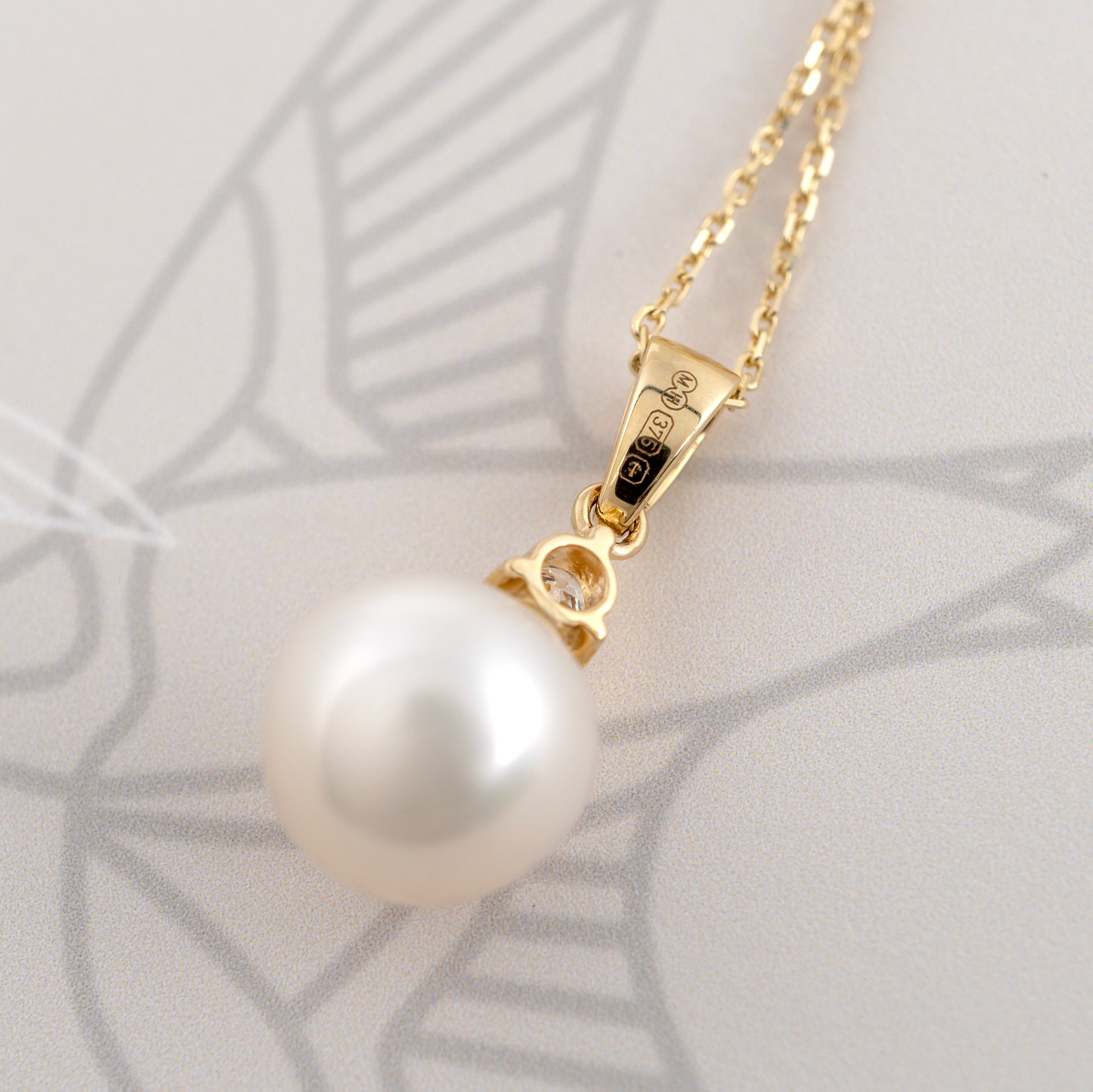 gold-pearl-necklace-close-up showing clear british assay hallmarks