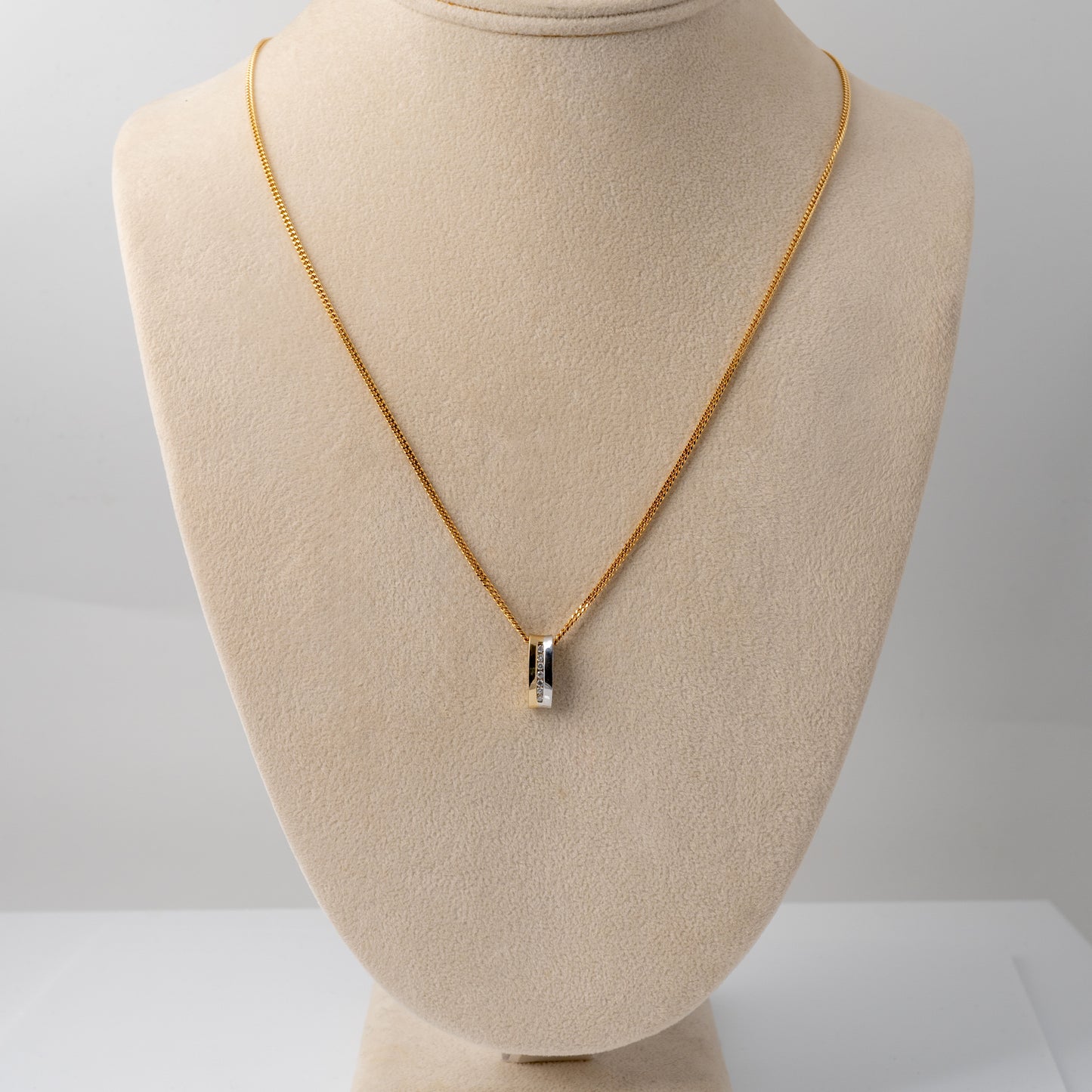 Two-tone gold diamond necklace on display bust