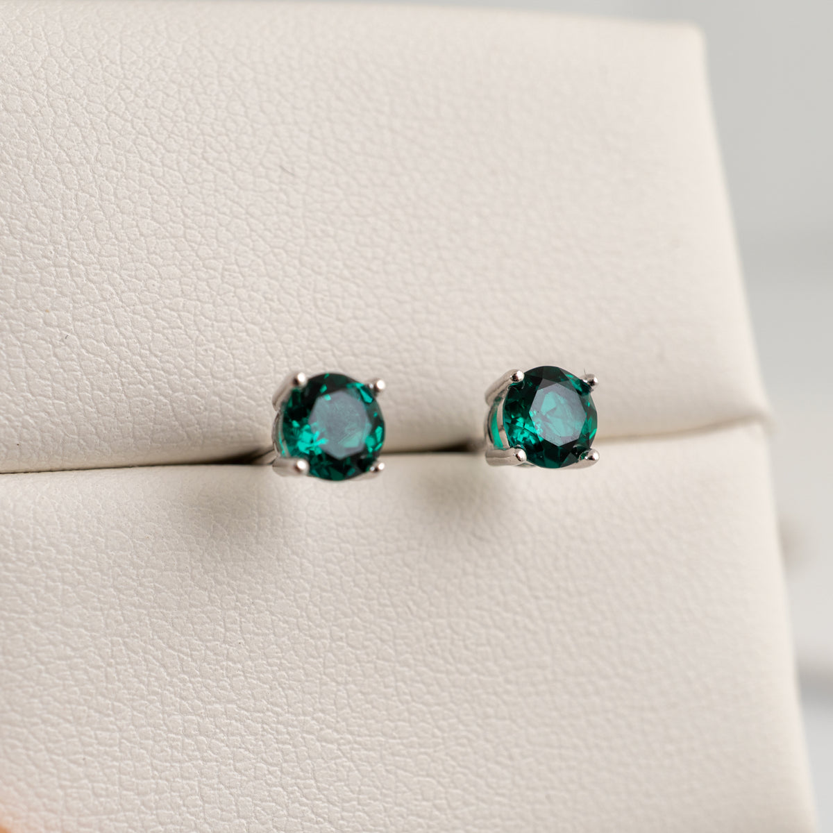 Deep green round lab-grown emerald stud earrings in polished sterling silver