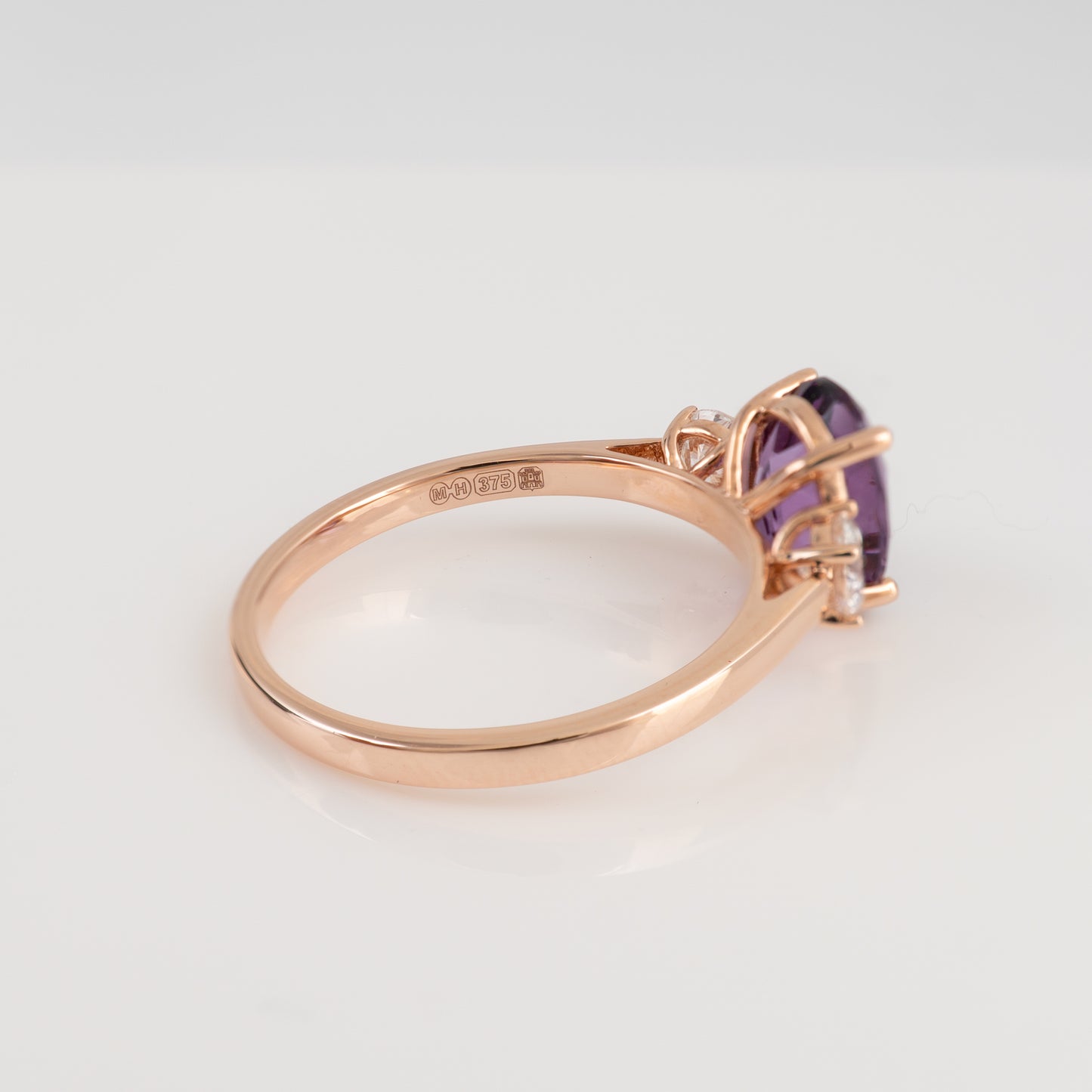 Side profile of amethyst and diamond three stone ring showing assay hallmarks – 9ct rose gold setting