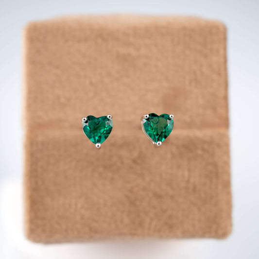Sterling silver emerald heart studs on brown base