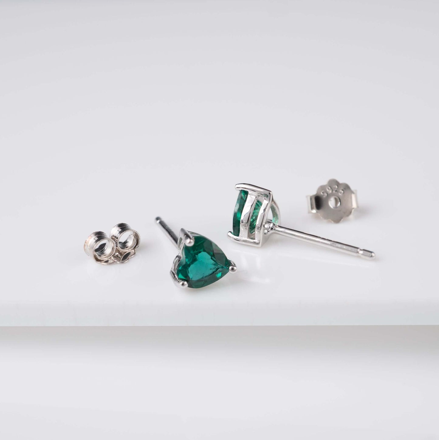 emerald-heart-stud-earrings-silver-flat-lay