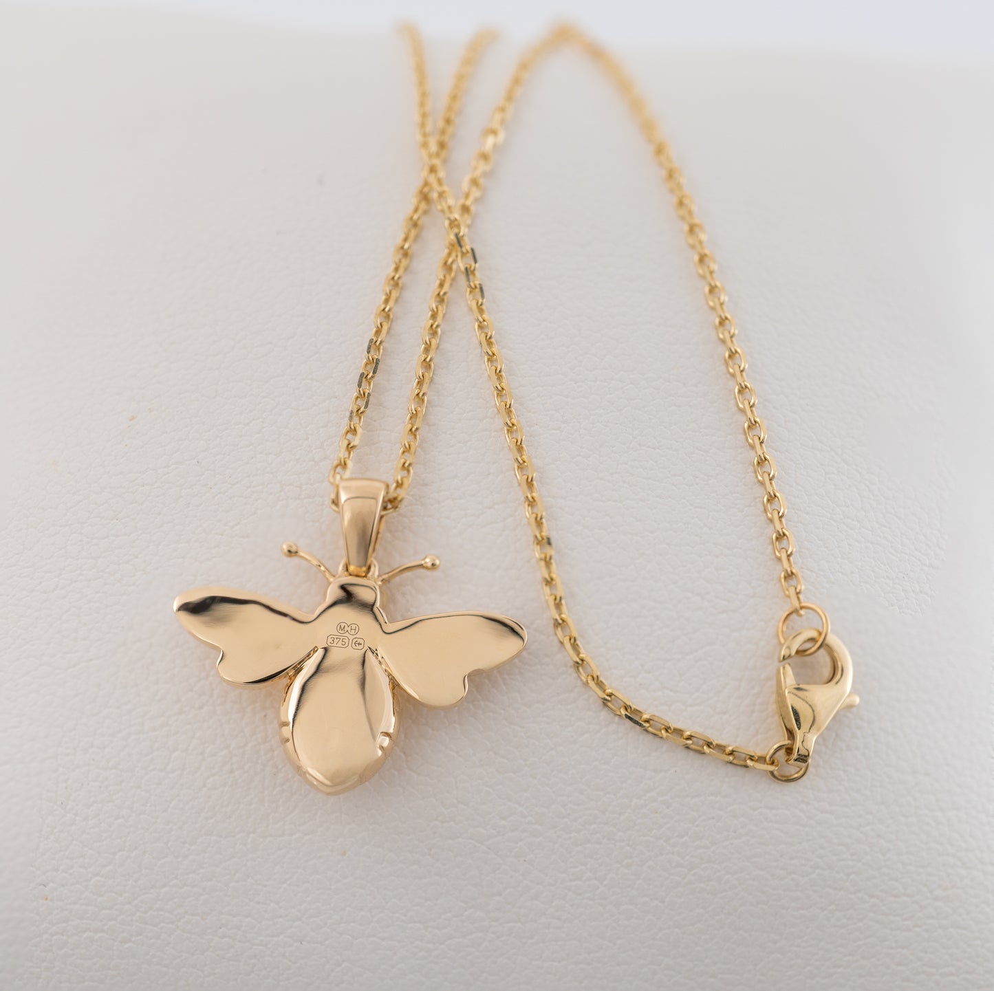 Close-up of the reverse side of the 9ct gold bee pendant necklace, featuring full Assay Hallmarks and secure lobster clasp