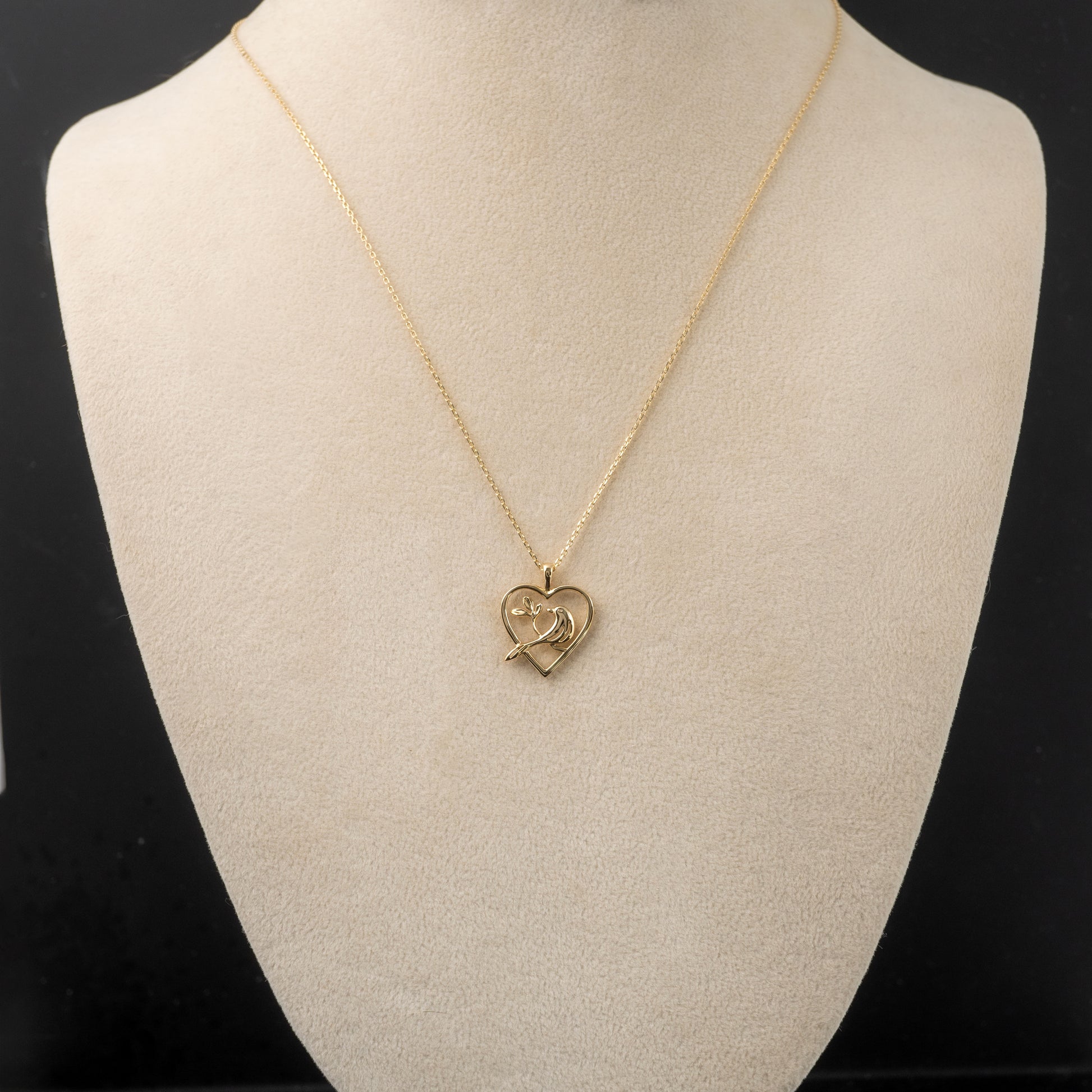 bird pendant heart necklace pendant on display bust