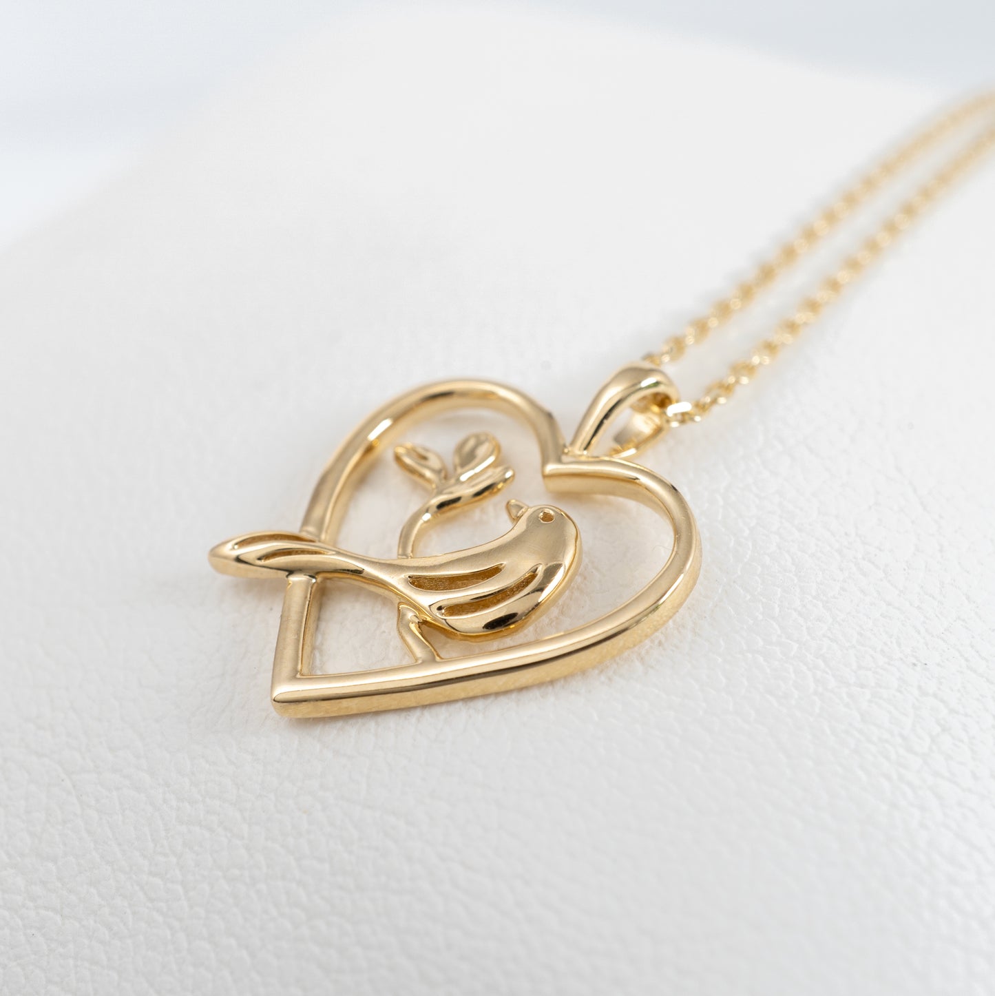 gold bird-in-heart pendant necklace close up