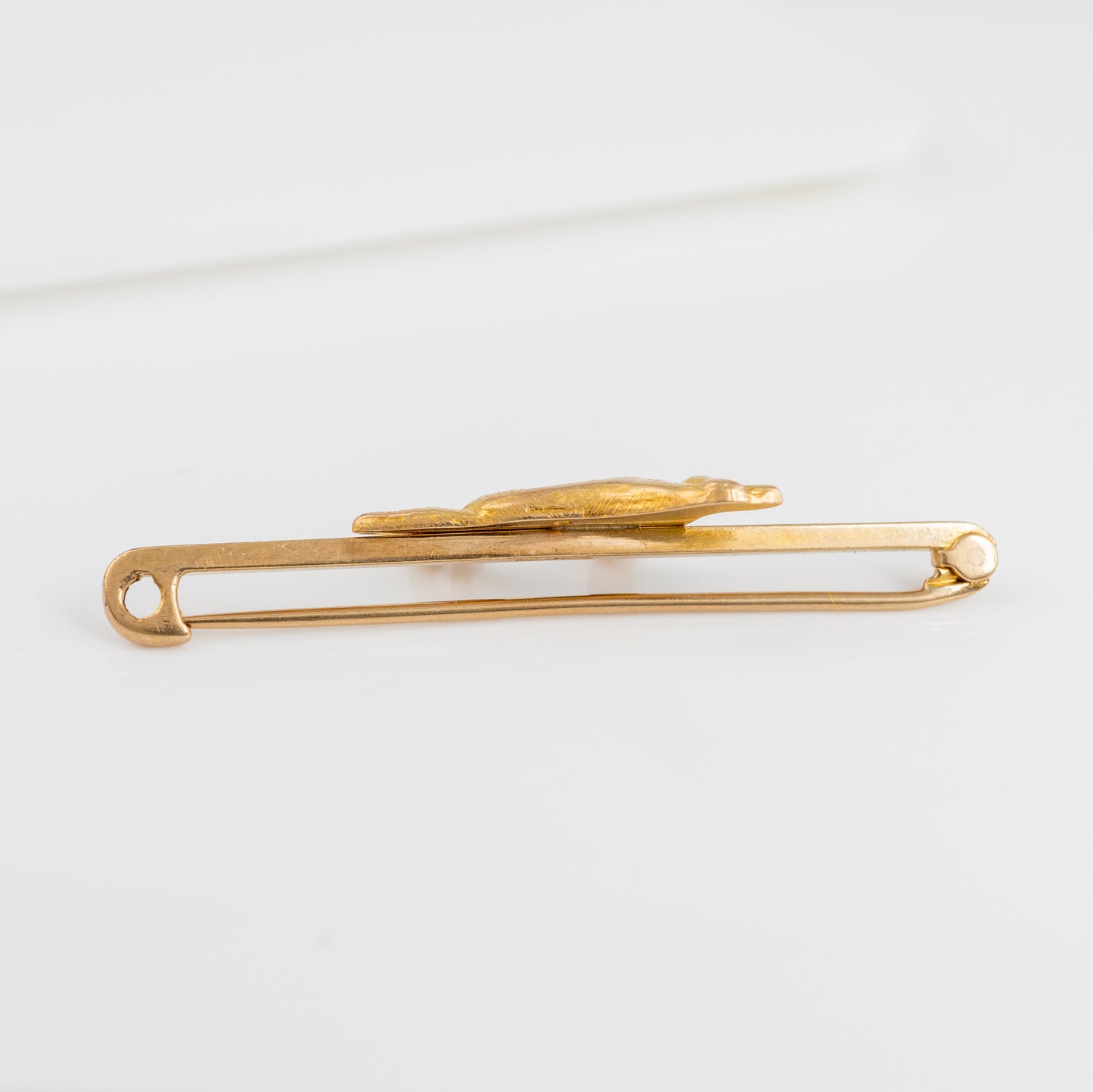 Side profile of a vintage 9ct gold dog brooch