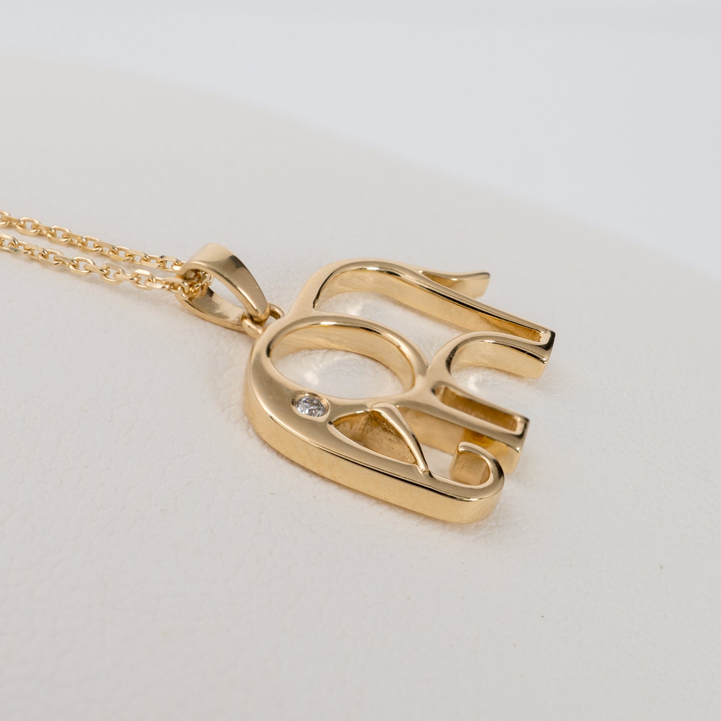 Side view of gold elephant pendant with adjustable chain