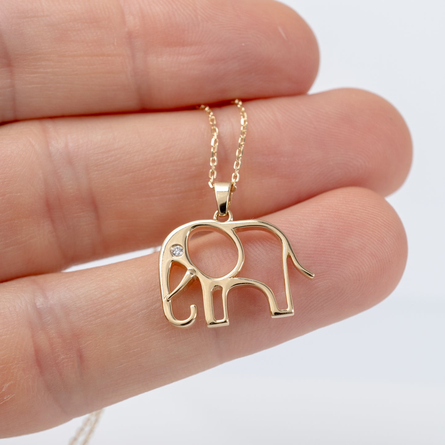 9ct gold elephant pendant with diamond – held in hand