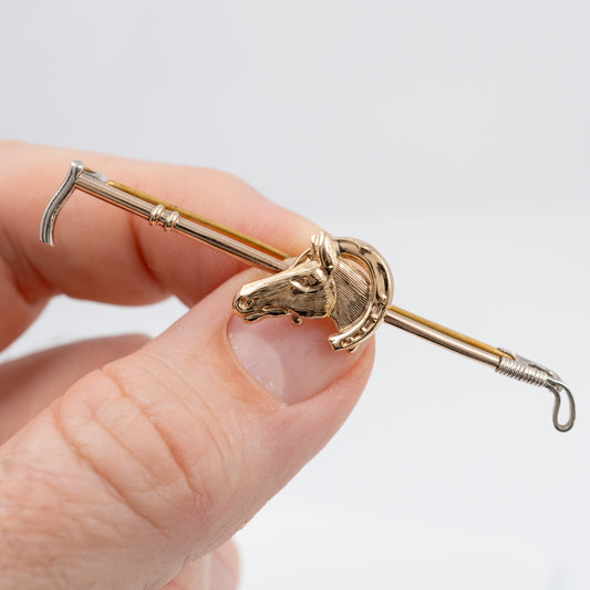 holding a vintage horse brooch gold