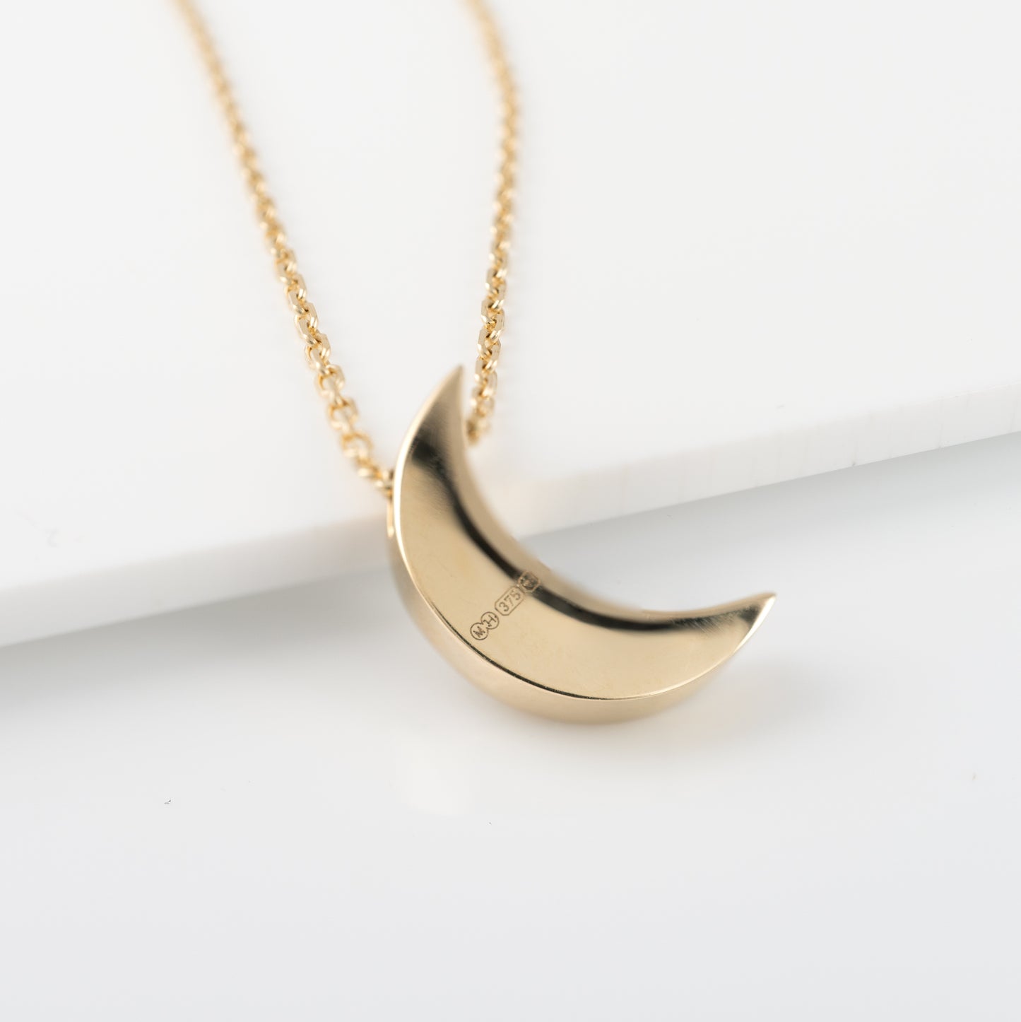 Back of 9ct gold moon crescent necklace showing british assay hallmarks hunters fine jewellery