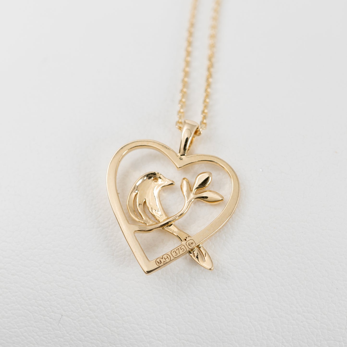 gold bird pendant reverse side showing assay hallmarks