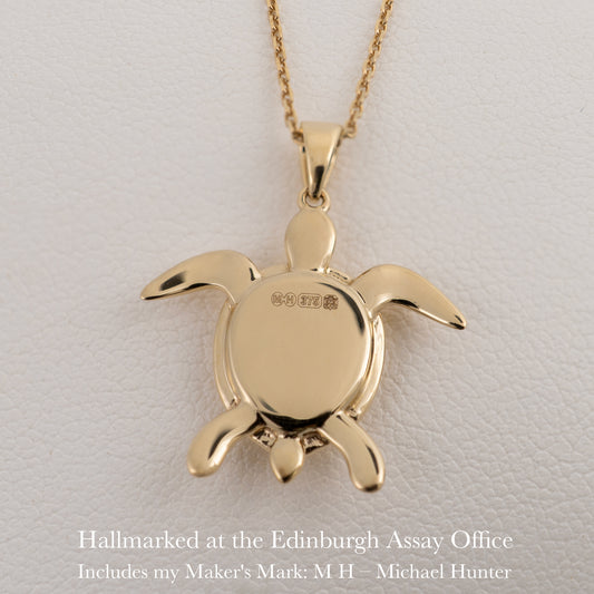 Back of gold sea turtle pendant showing Edinburgh hallmark and maker’s mark