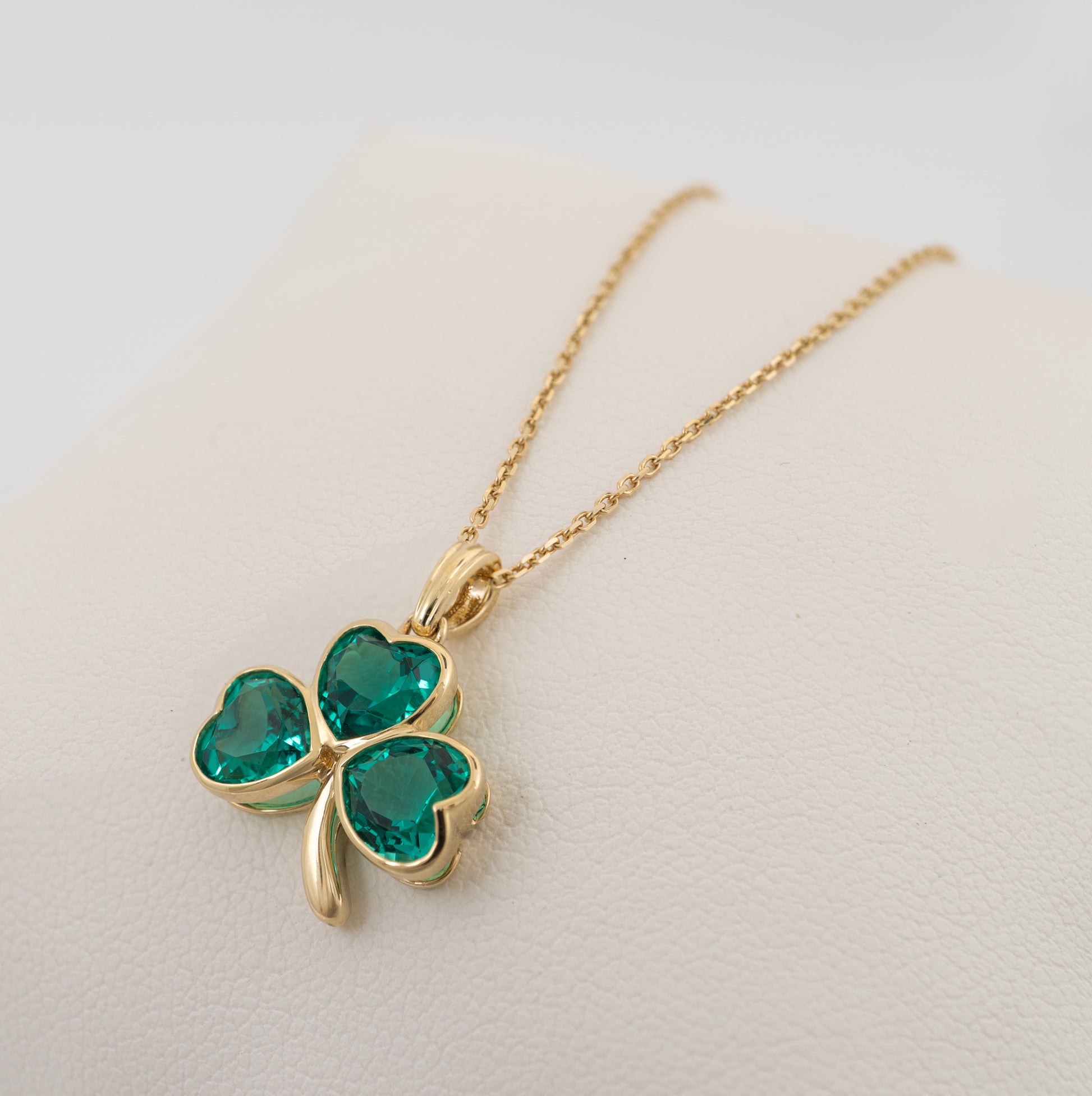 Lab emerald shamrock pendant held in hand on chain