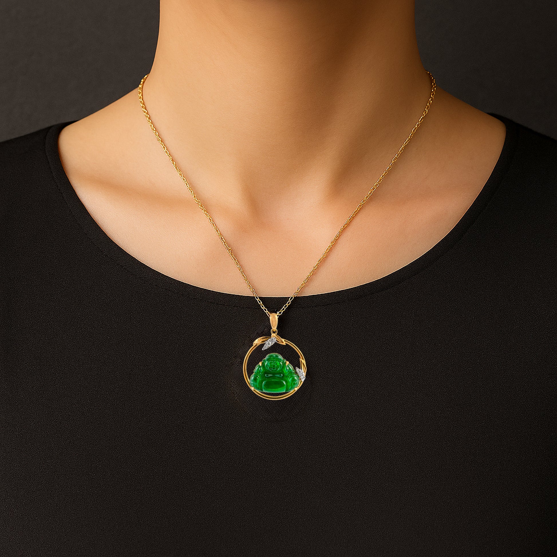 Gold necklace with a green pendant on a black background