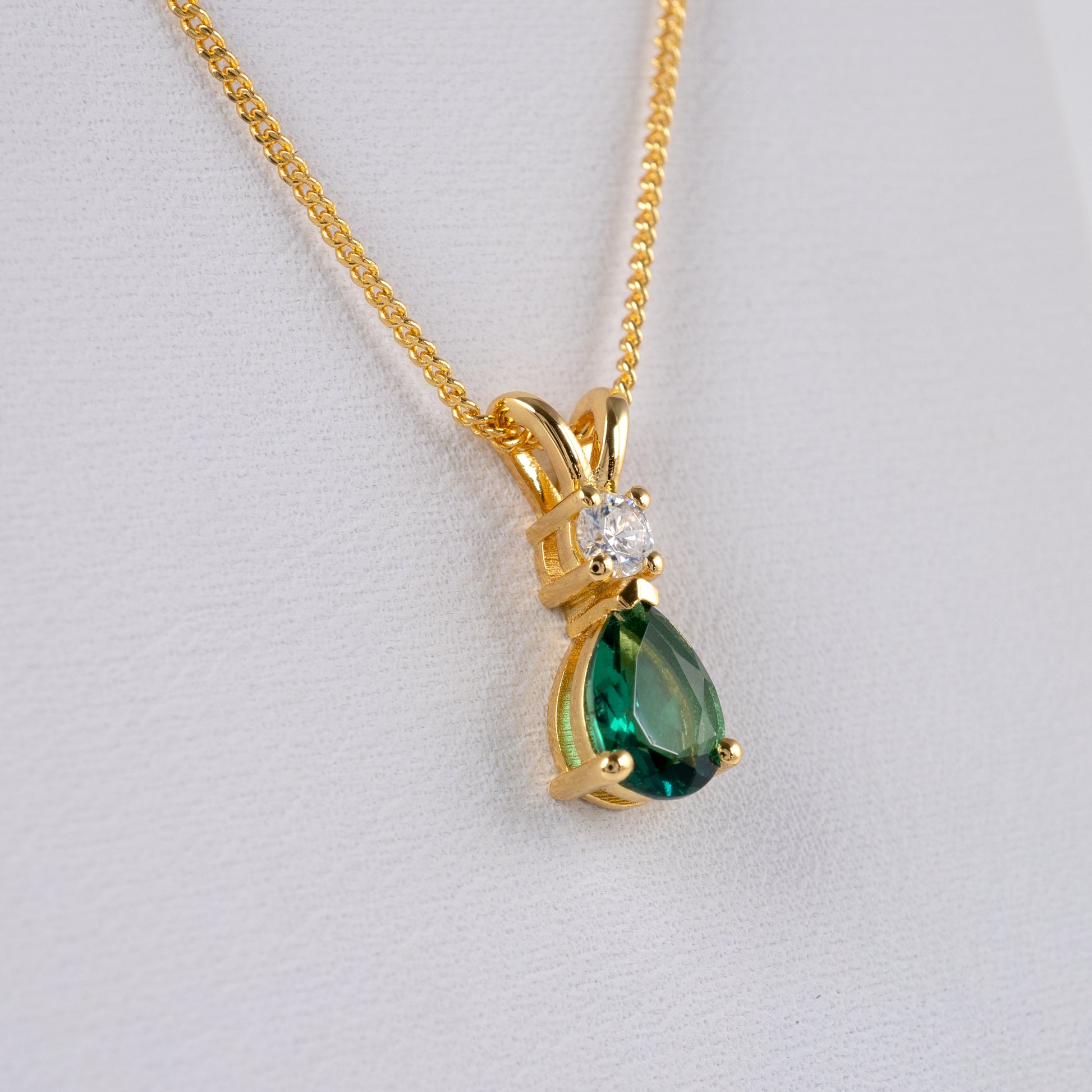 Side view of lab emerald pendant showing moissanite detail and vermeil setting
