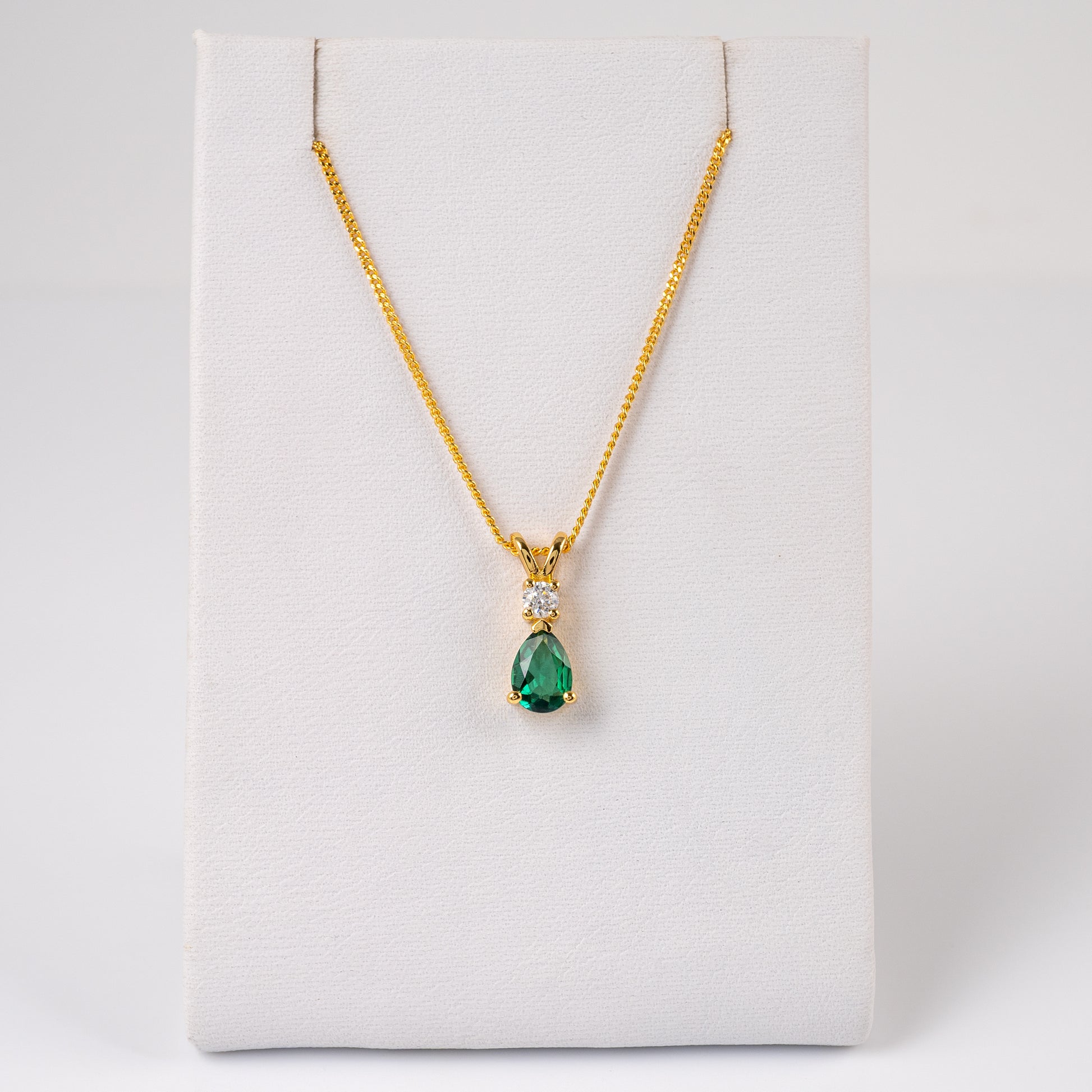 Full length view of lab emerald pendant necklace on white display card