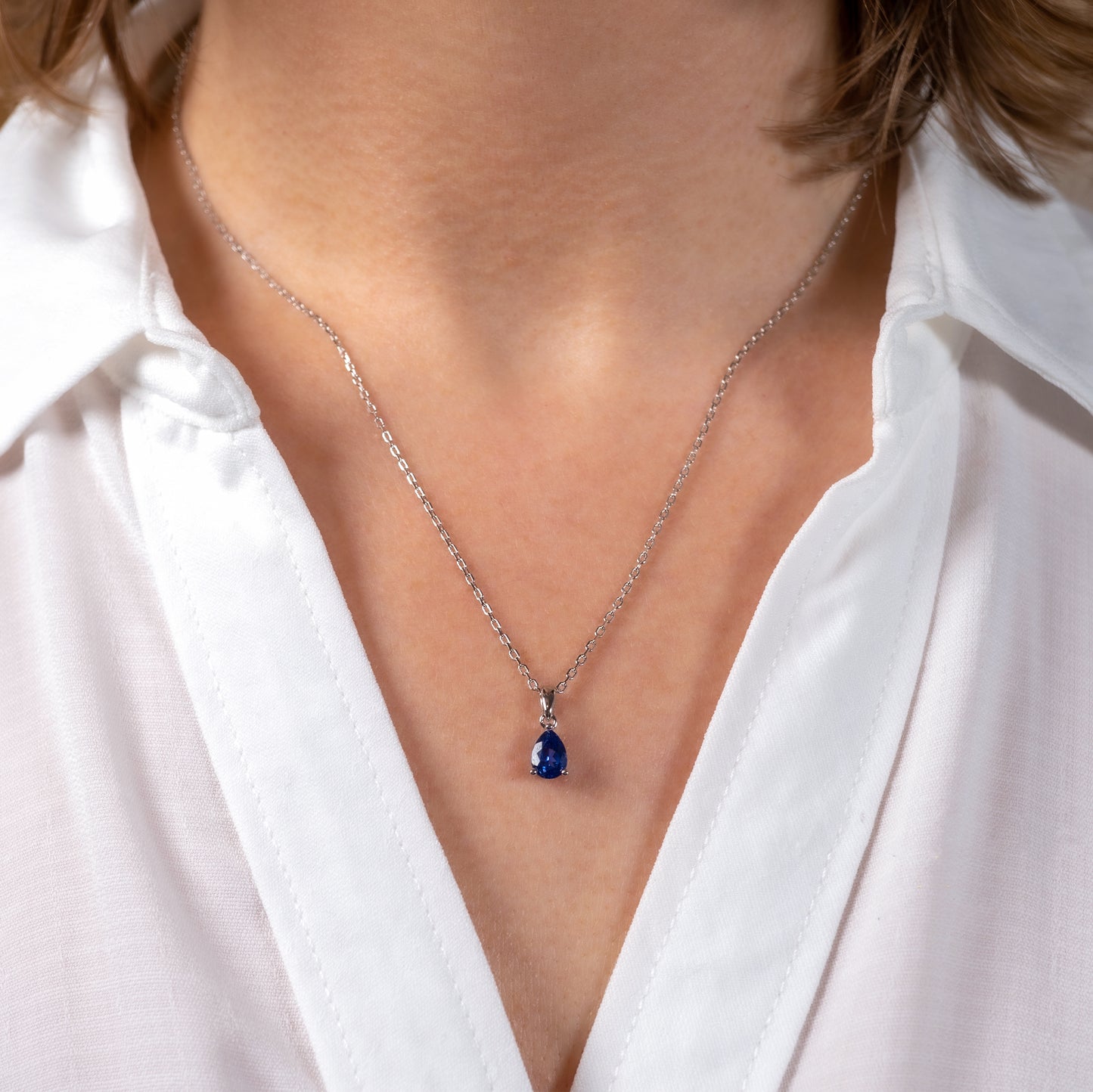 Lab grown sapphire teardrop necklace shown worn on model
