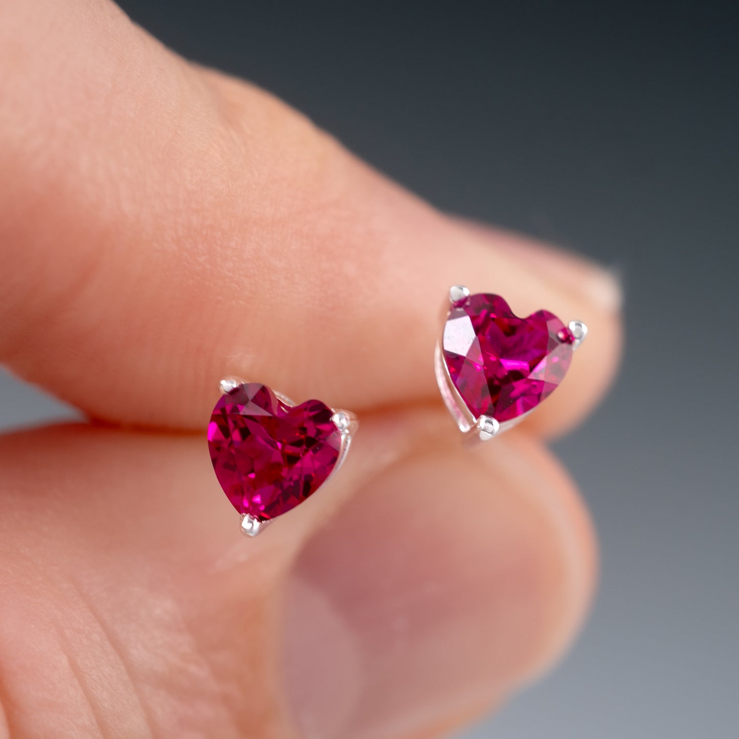 lab-ruby-stud-earrings close up in fingers