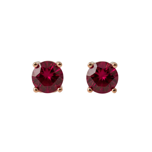 Pair of lab ruby stud earrings on a light gray background