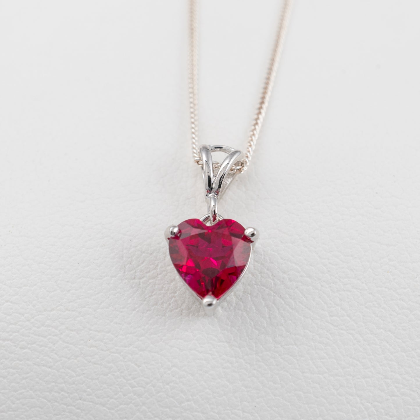 lab ruby heart necklace showing three prong setting and silver split bail