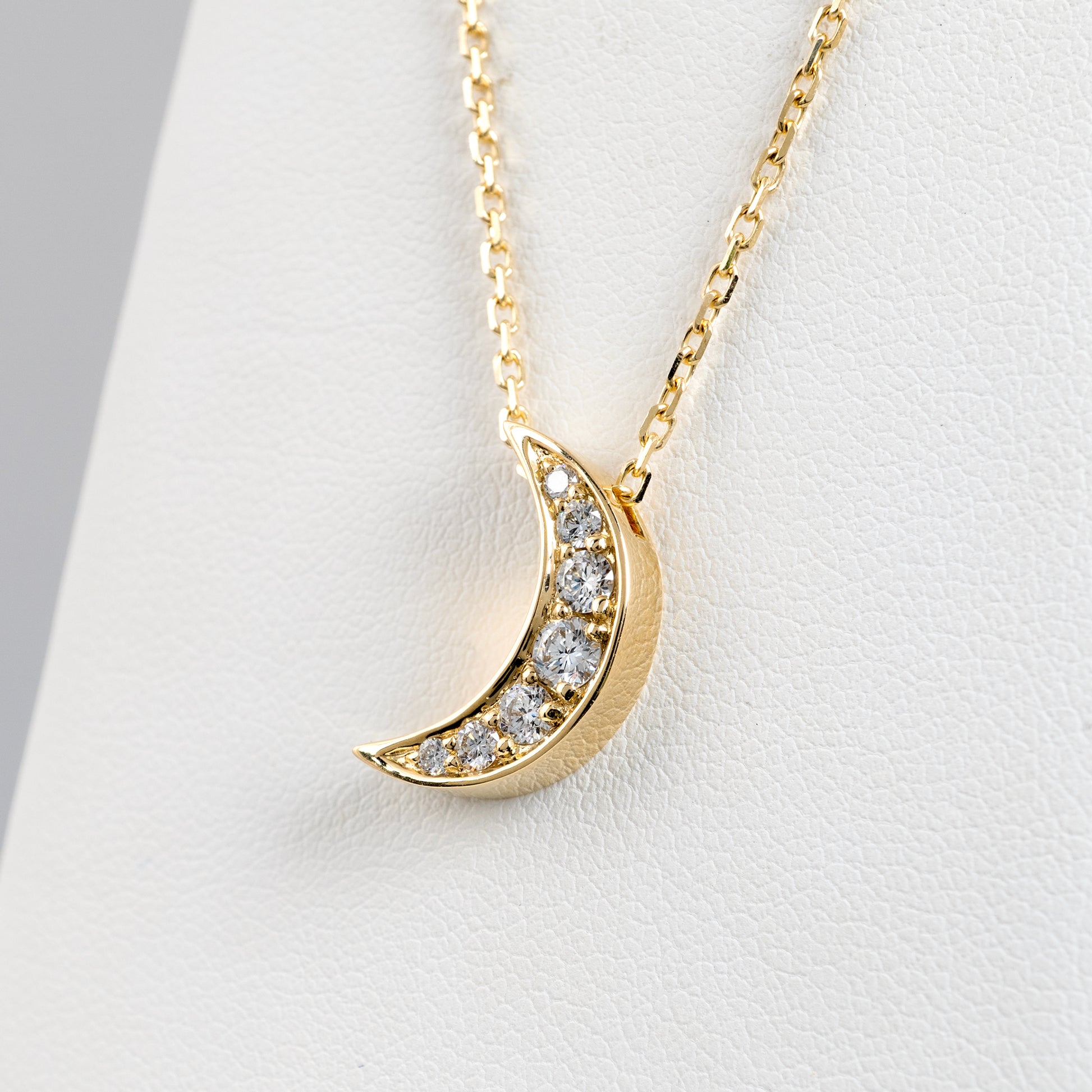 Close-up of crescent diamond necklace in 9ct yellow gold