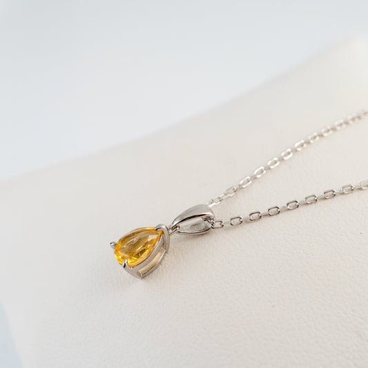 Side angle of the natural citrine teardrop necklace showing the silver setting and bail.