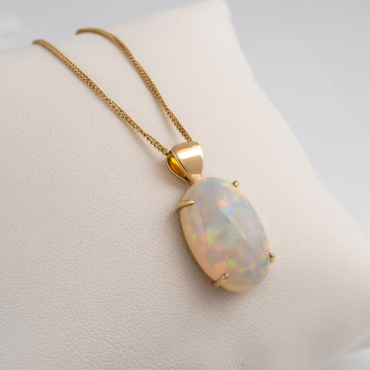 Opal stone pendant necklace on a mannequin bust with a plain background