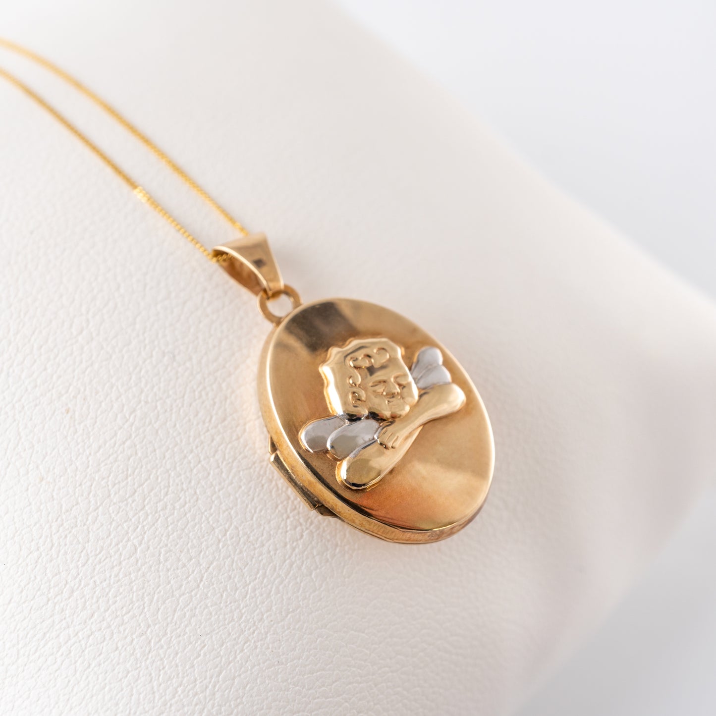 Pre-owned 9ct gold cherub pendant locket on display cushion – Hunters Fine Jewellery