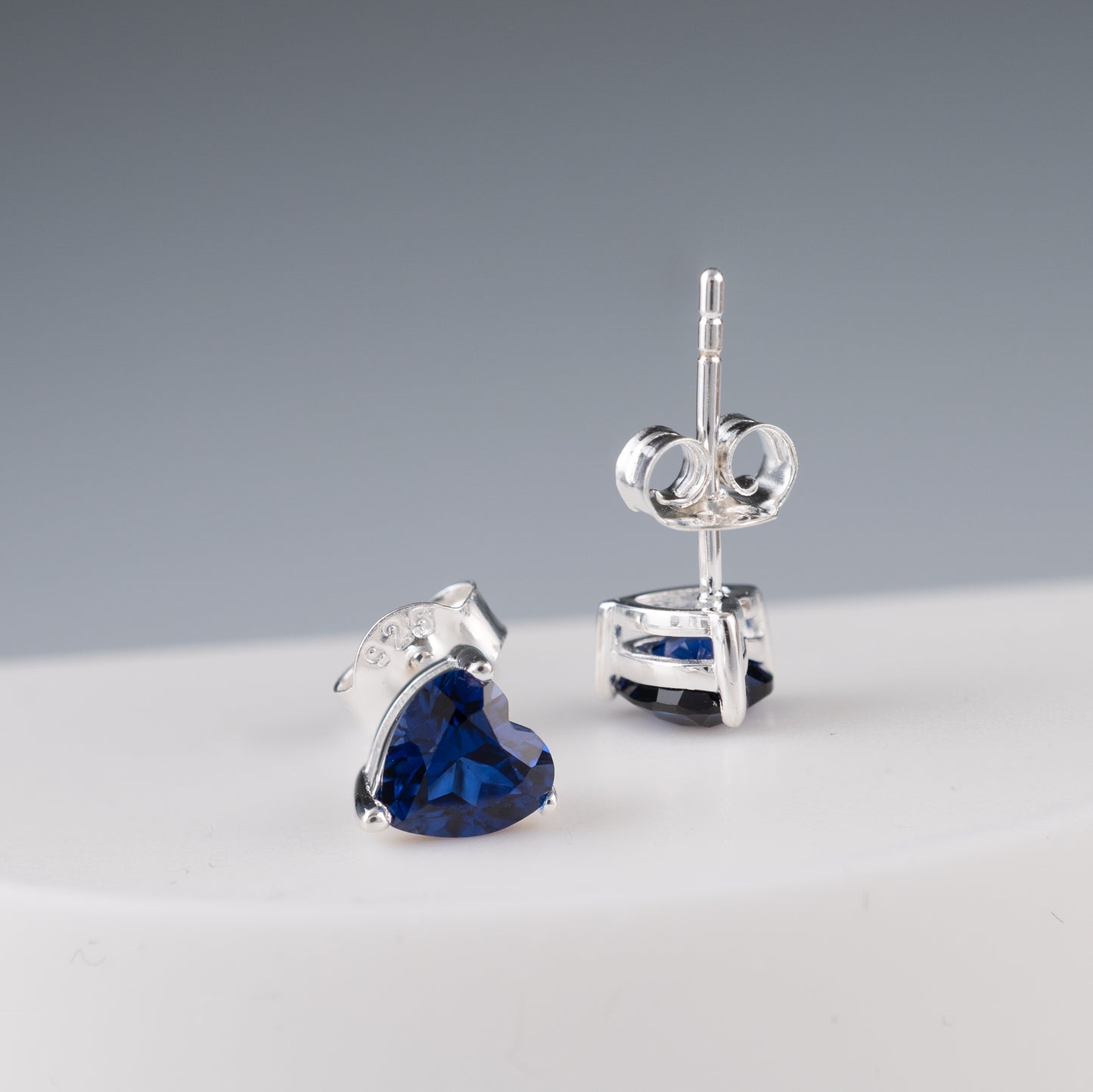 Lab sapphire heart studs with secure post backs – angled view