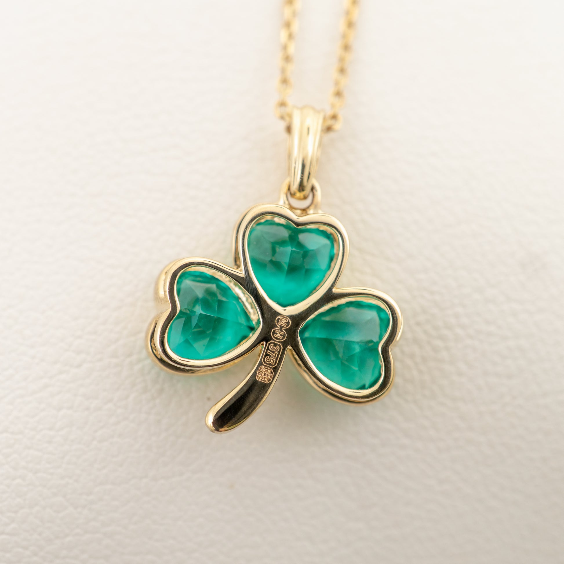 Close-up of edinburgh hallmarks on back 9ct gold shamrock pendant