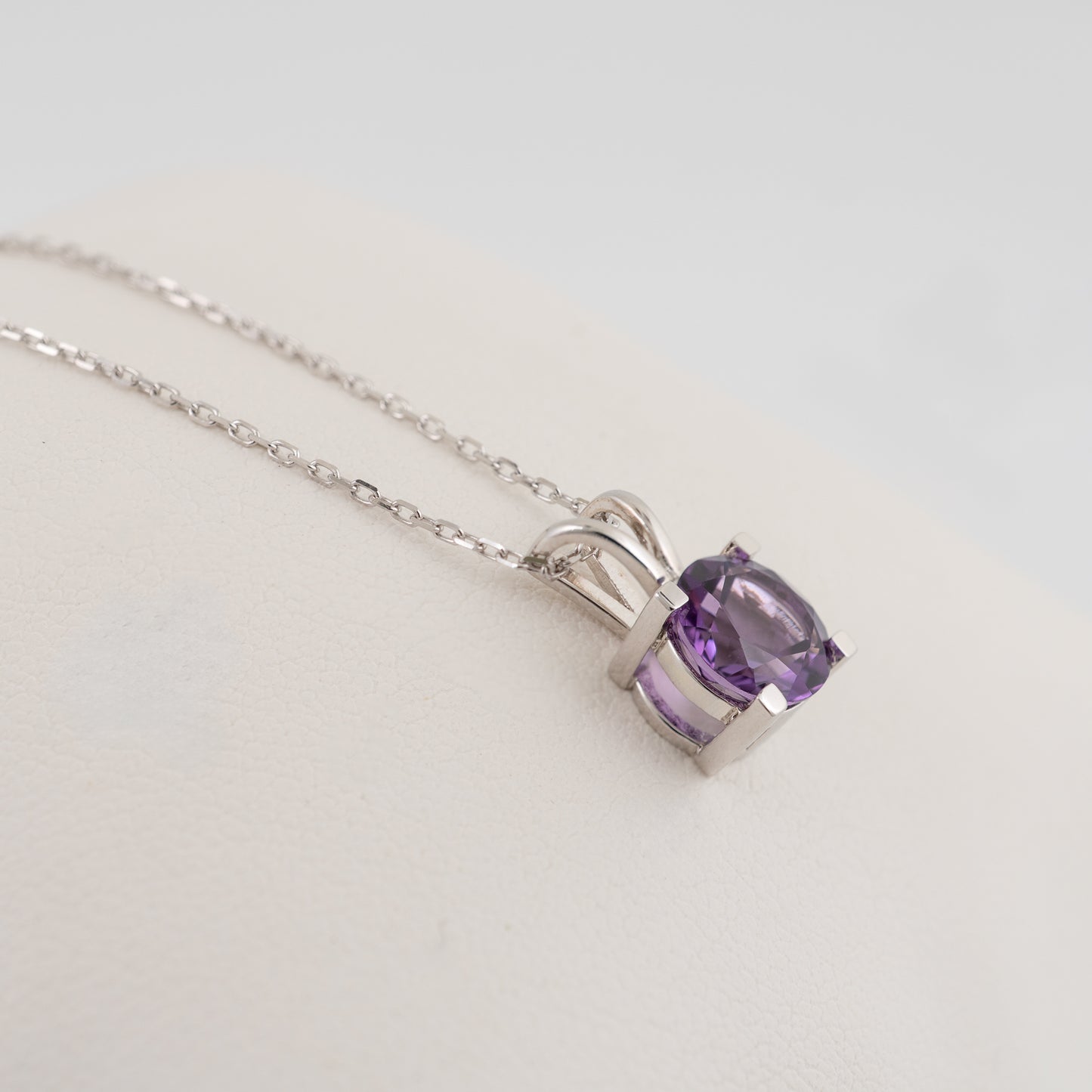 Side view of amethyst necklace showing V-bale and stone cut in silver