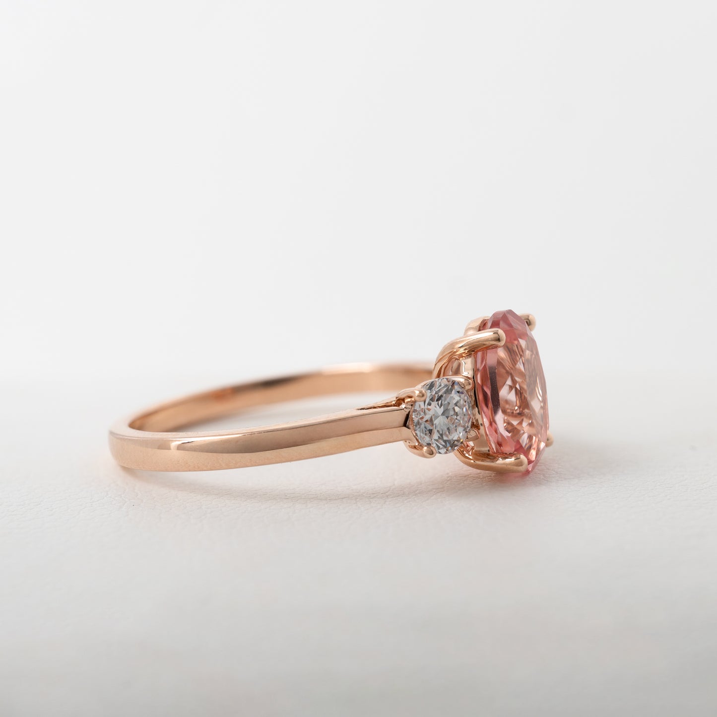 Side profile of sunrise padparadscha sapphire and diamond ring in rose gold by Hunters Fine Jewellery