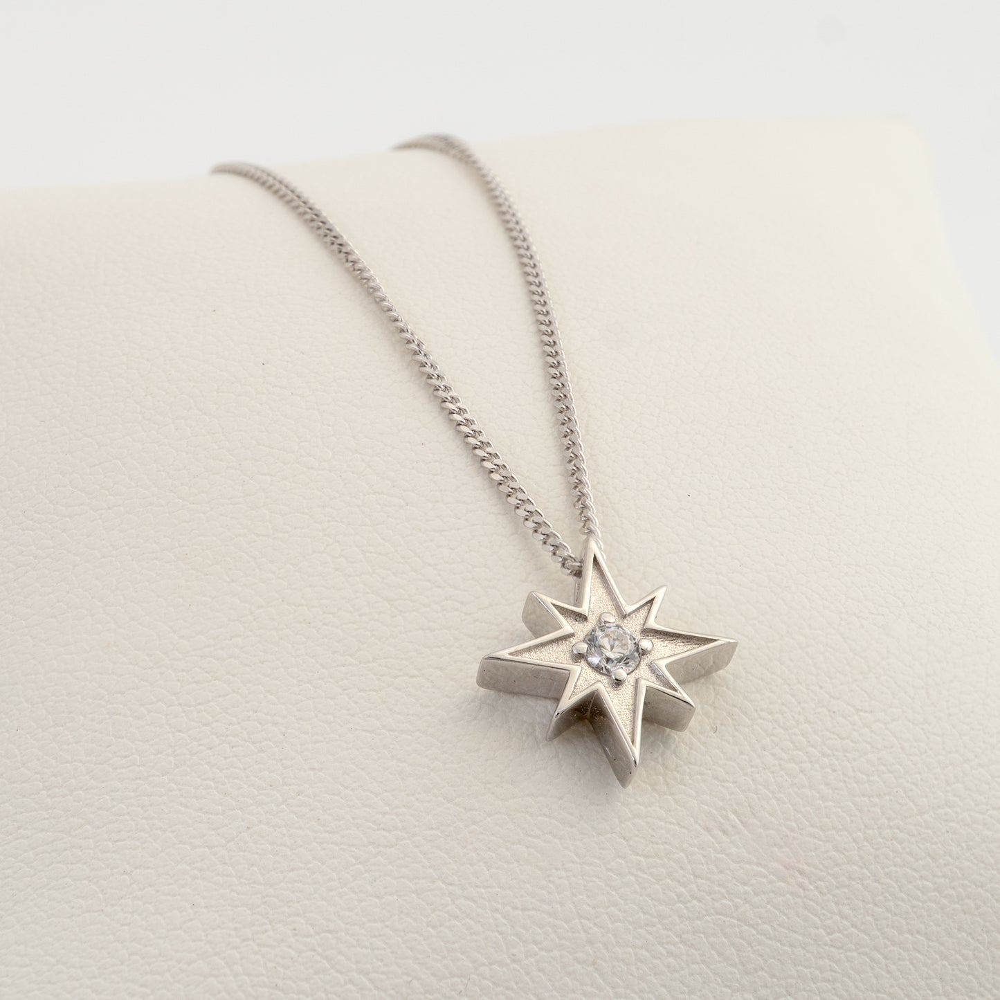 Angled view of silver North Star necklace with clear stone pendant