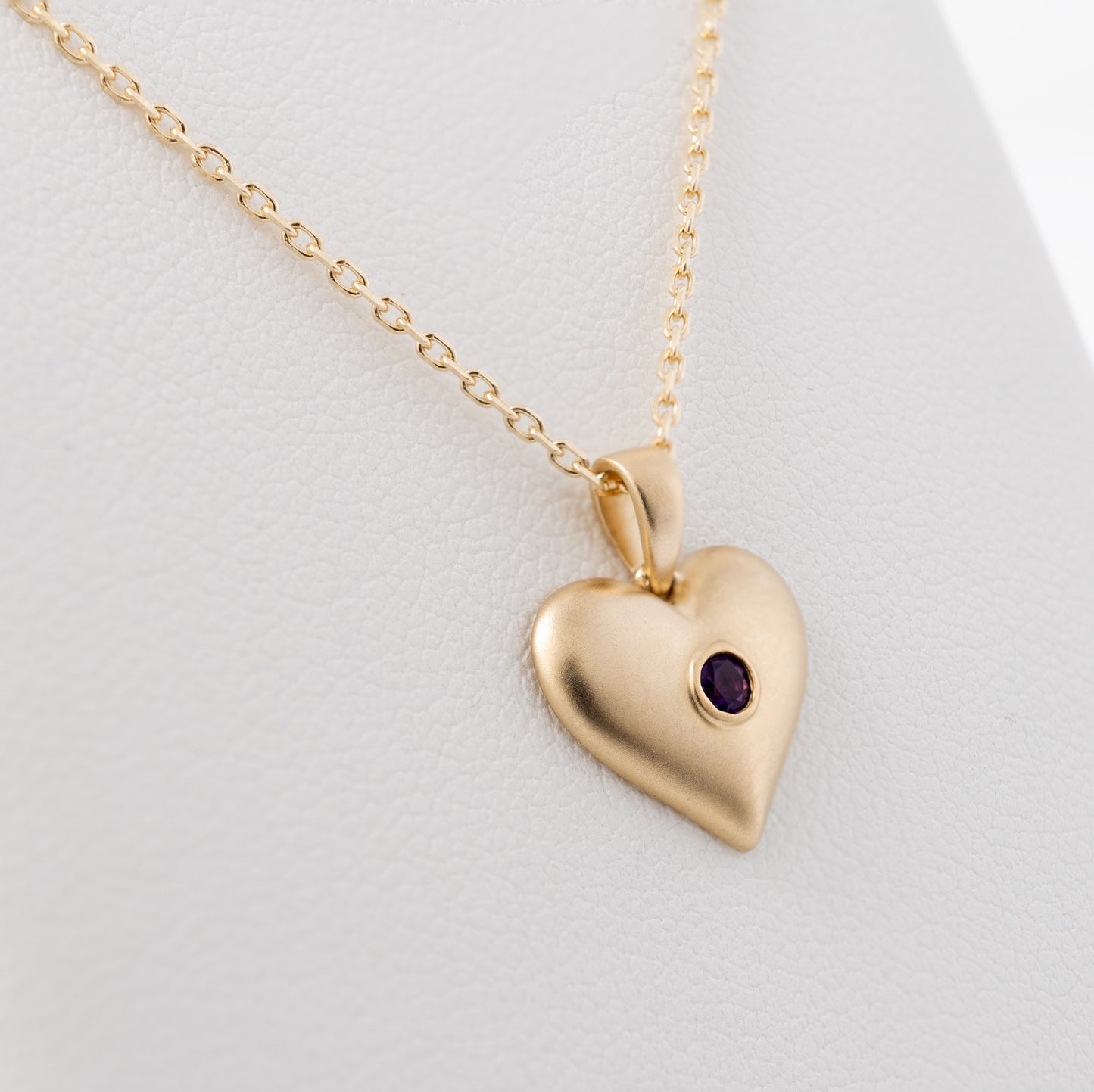 close up of amethyst heart necklace puffy matte gold finish