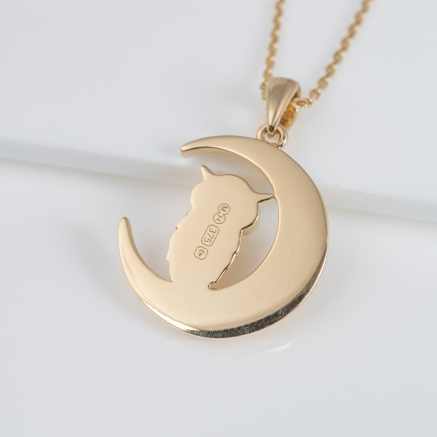 Reverse of gold owl pendant showing hallmark and maker's mark