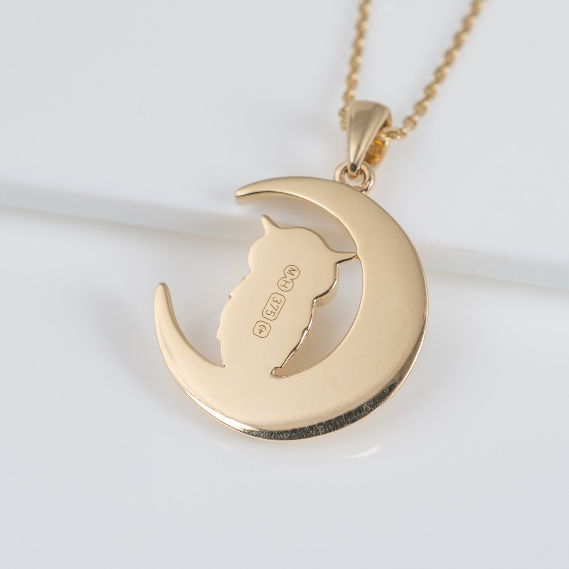 Reverse of gold owl pendant showing hallmark and maker's mark