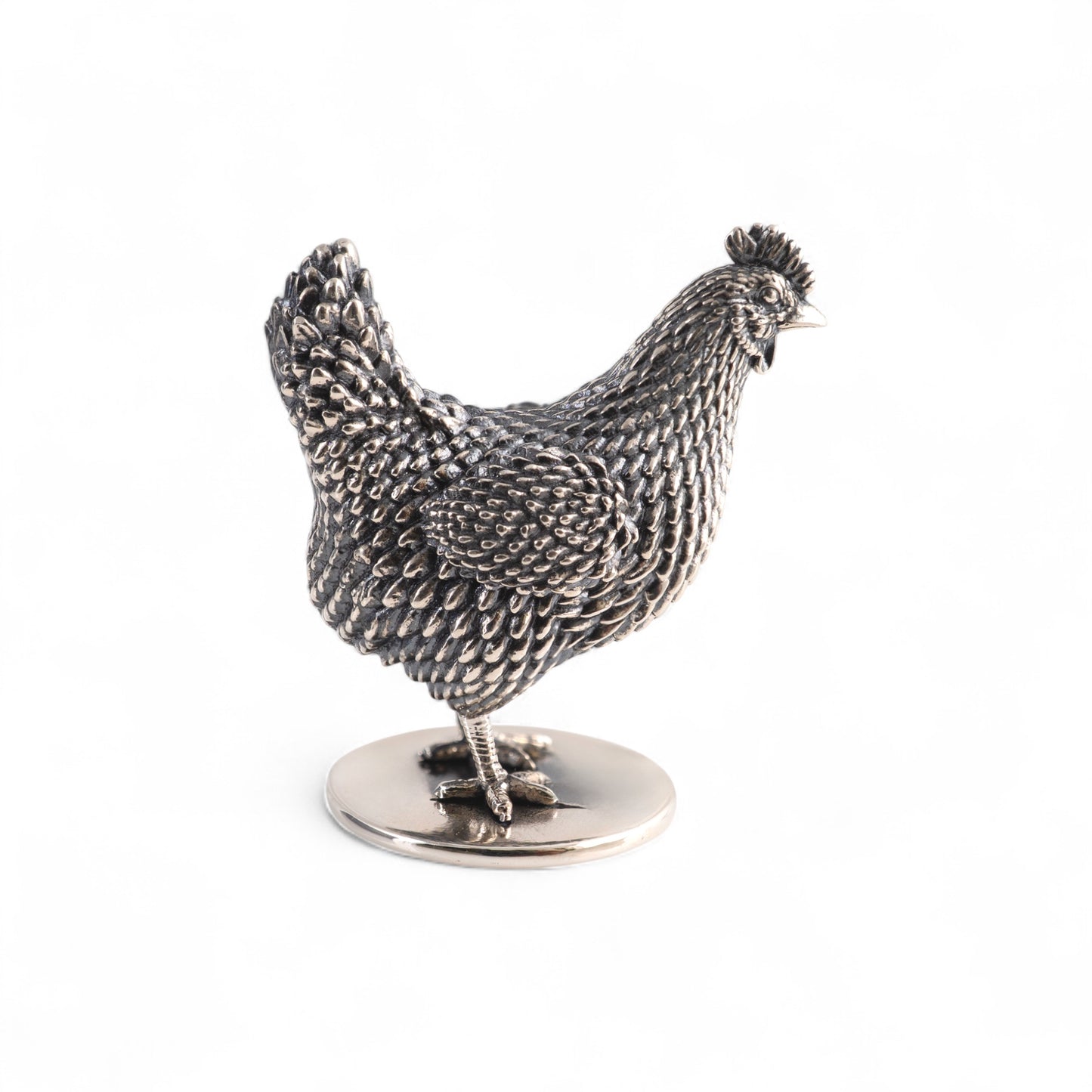 sterling silver hen miniature figurine on circular base side on a white background