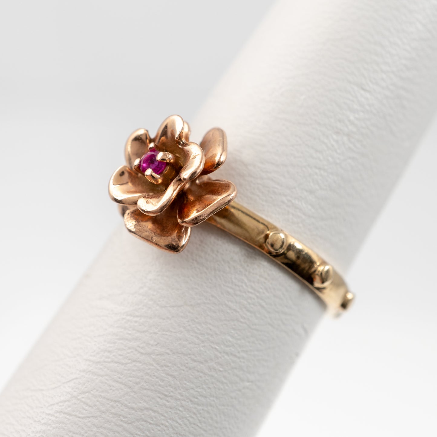 Close-up of rose gold flower setting with ruby on 14K rosary ring