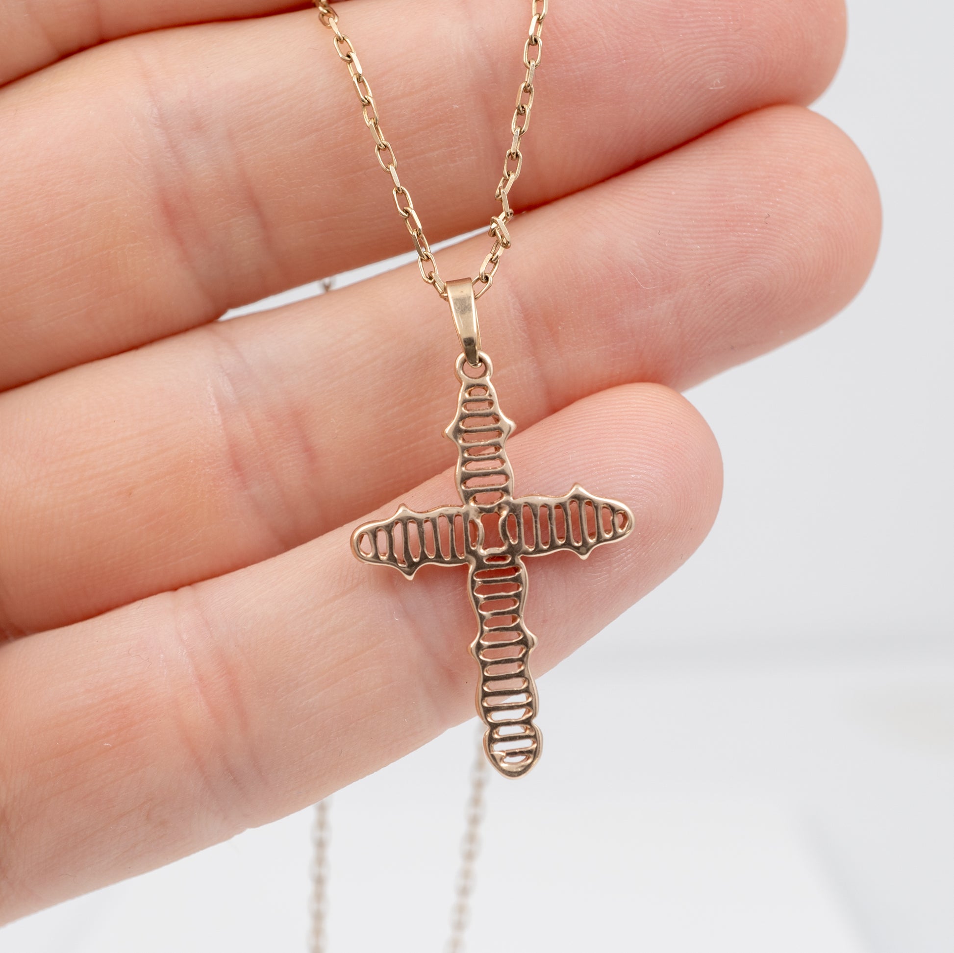vintage 9ct gold crucifix necklace in a hand